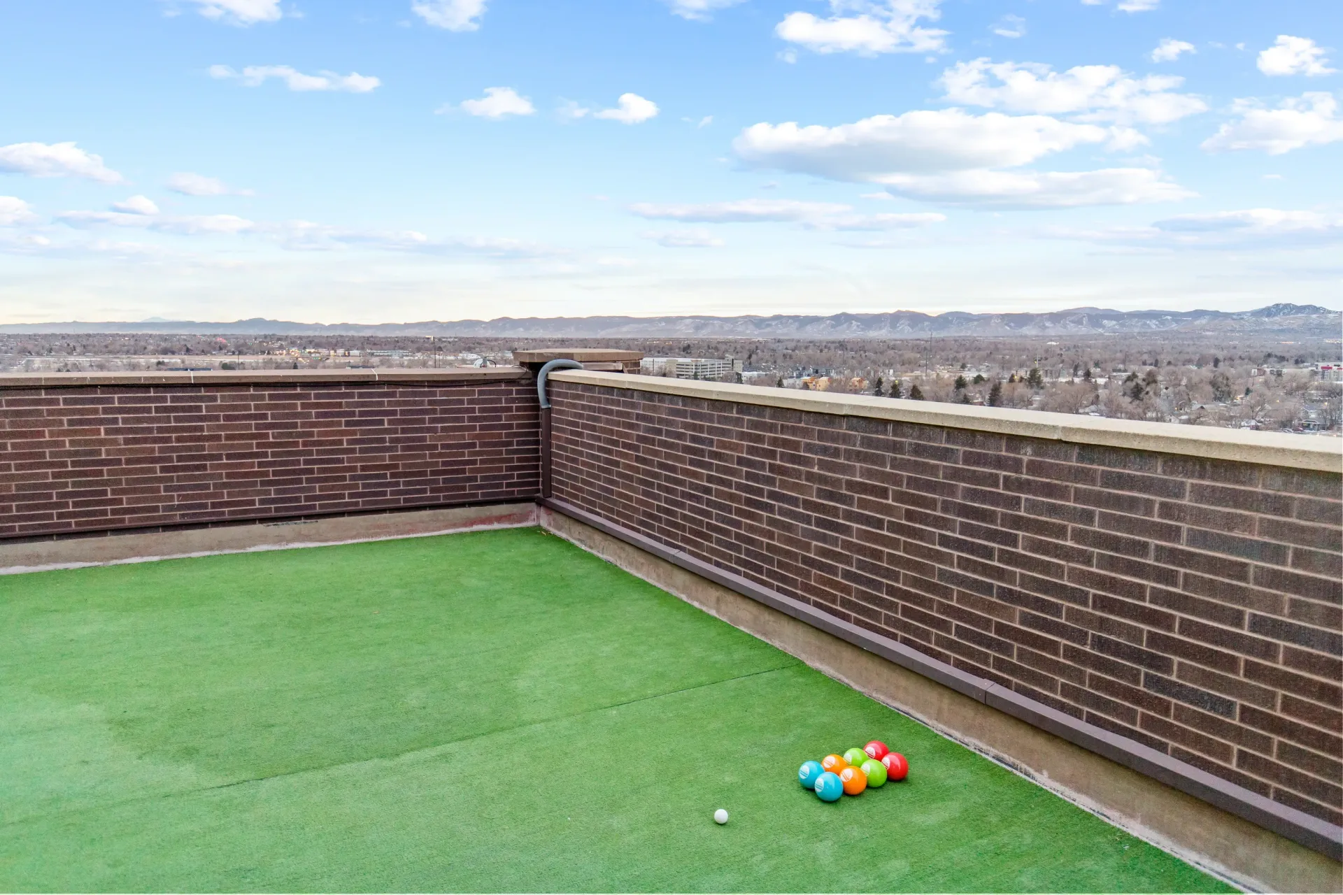 Rooftop patio with bocce ball court and scenic city views.