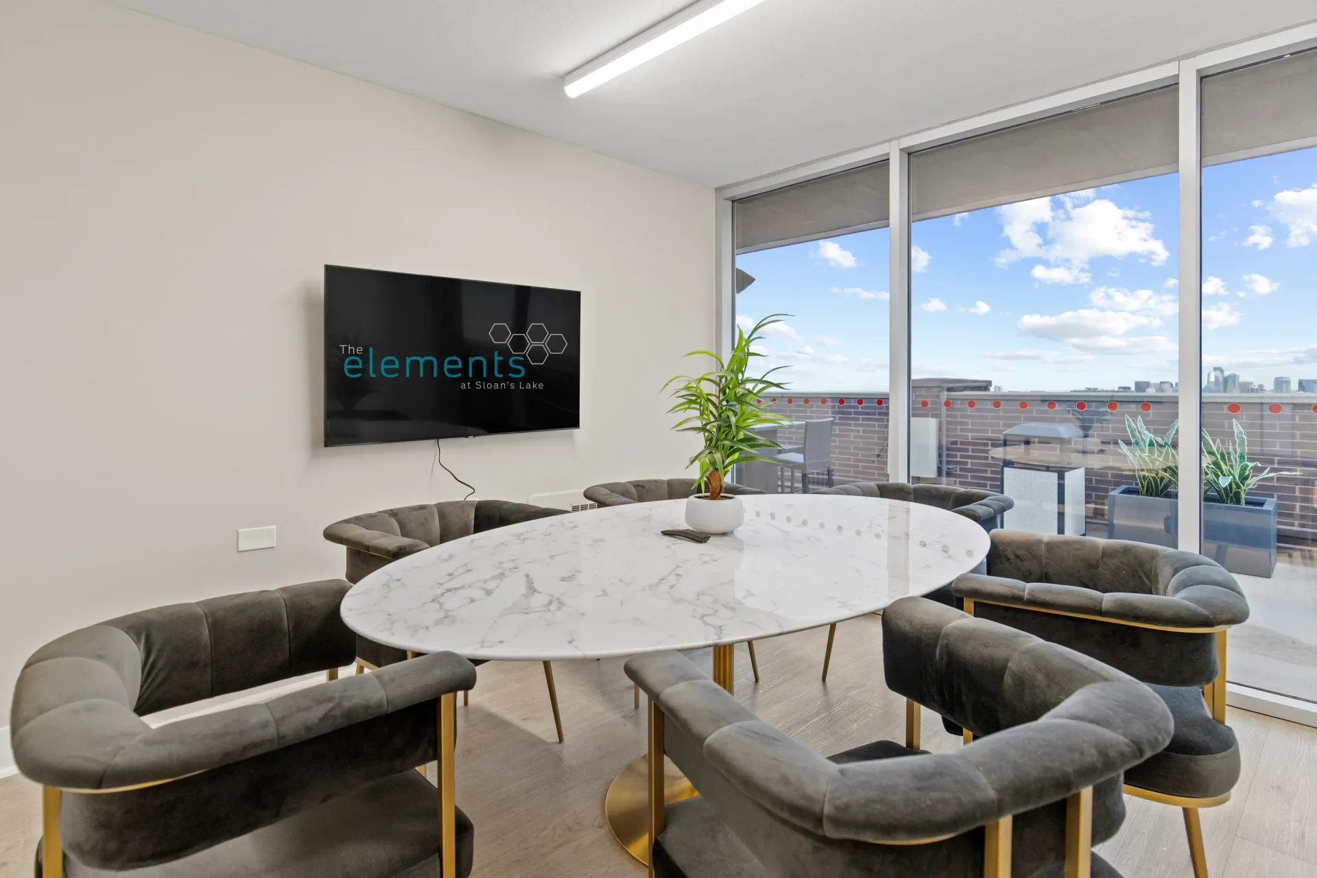 The Elements at Sloan's Lake logo displayed on a TV screen in a community lounge.