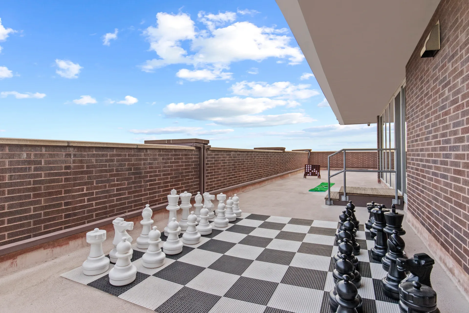 Oversized chess set on a rooftop patio.