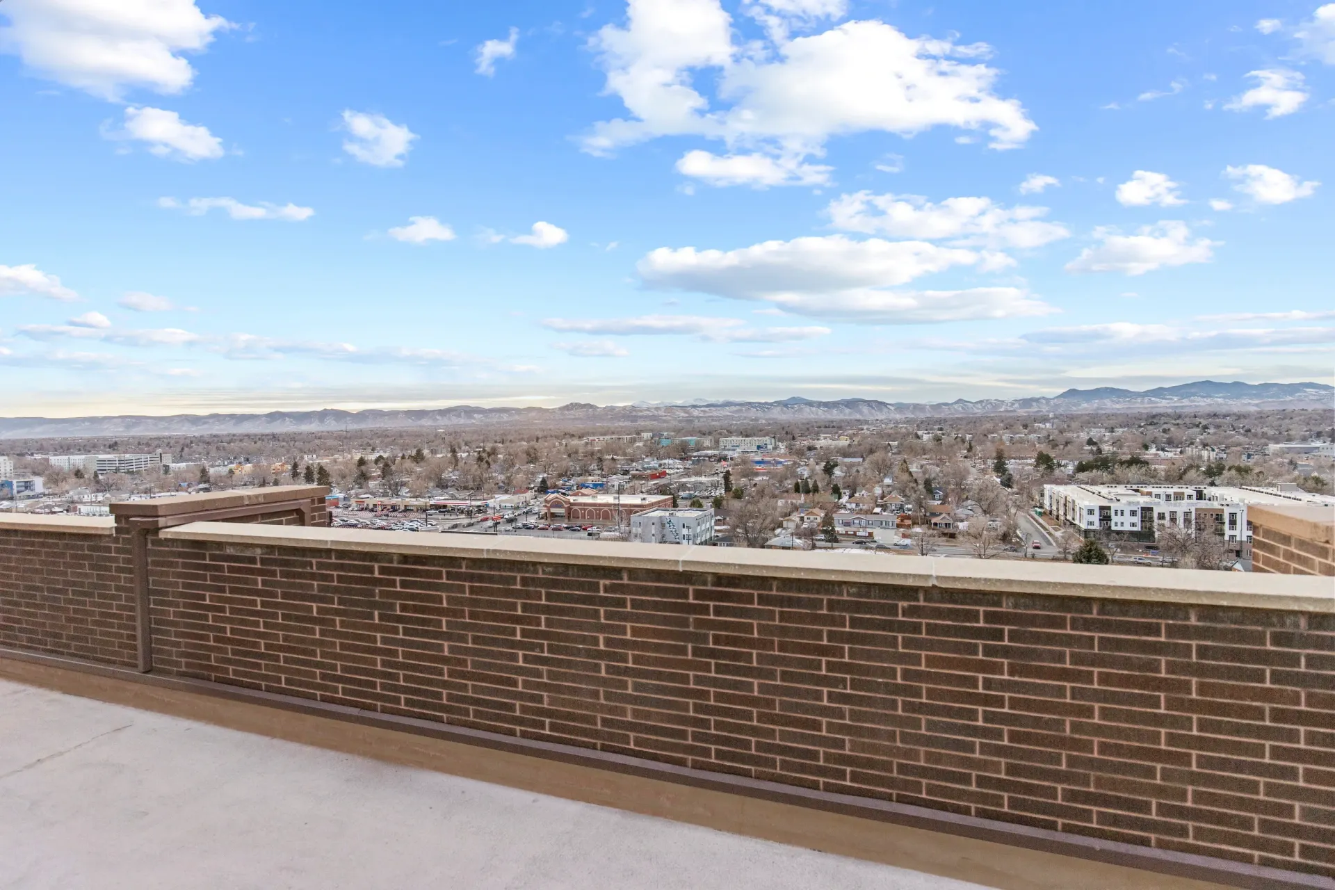 Rooftop view overlooking a city with mountains in the background.
