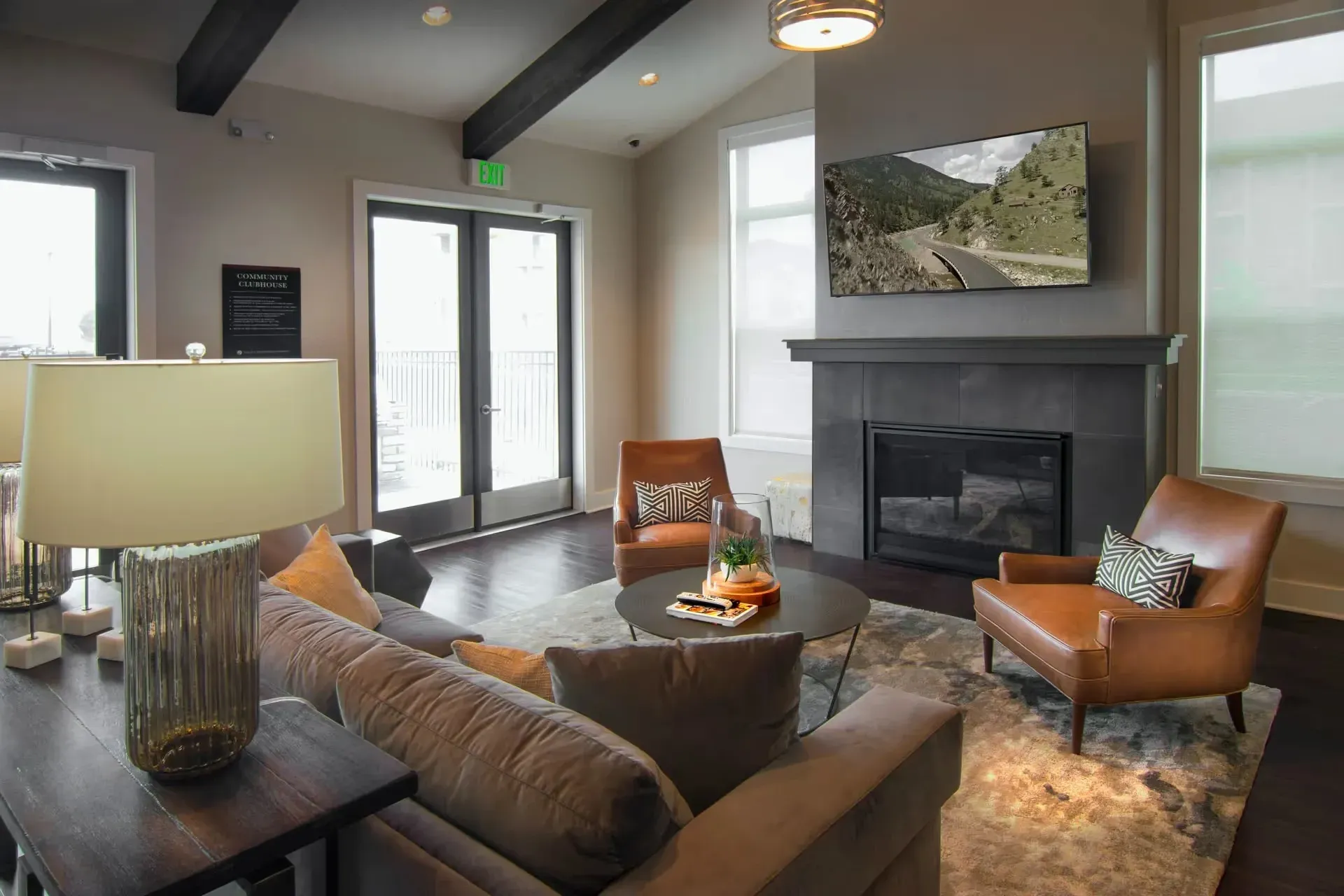 Comfortable seating area with a fireplace and TV in the community lounge.
