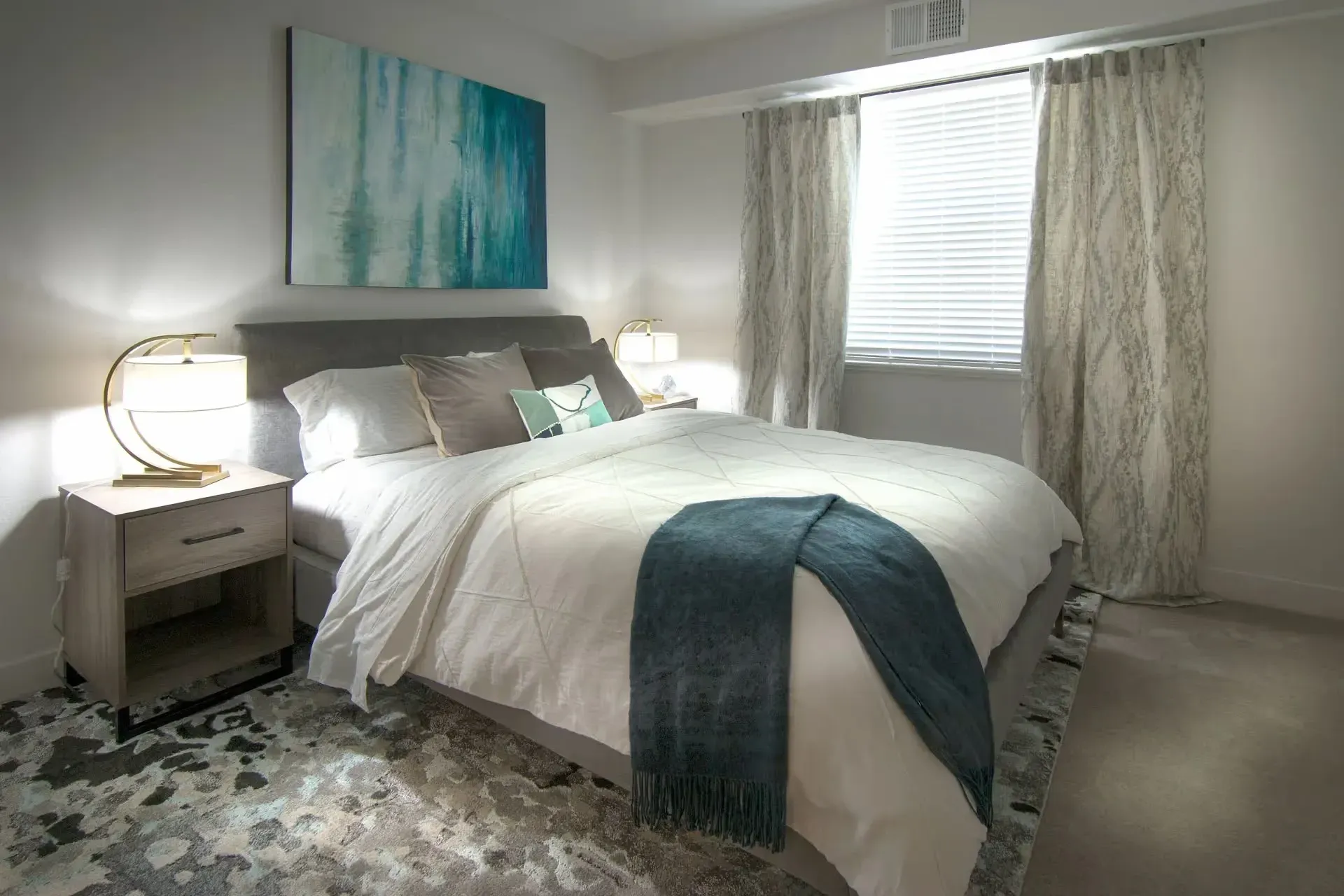 Bedroom with a king-size bed, nightstand, and abstract wall art.