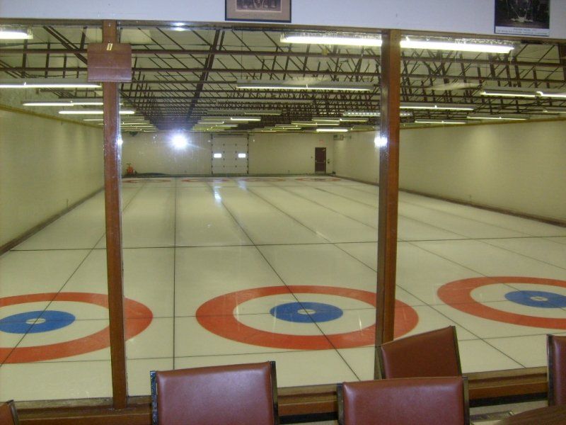 A curling rink with red white and blue circles on the floor