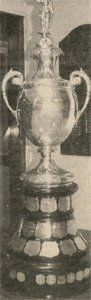 A black and white photo of a trophy on a pedestal.