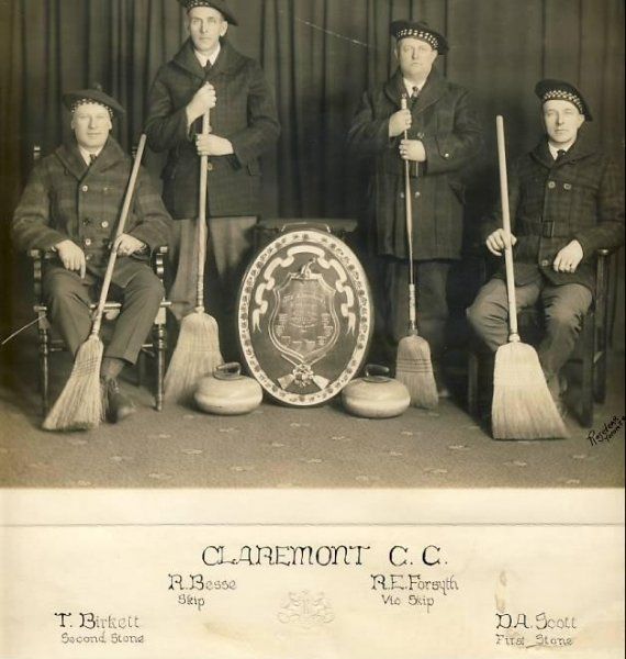 A black and white photo of a group of men holding brooms