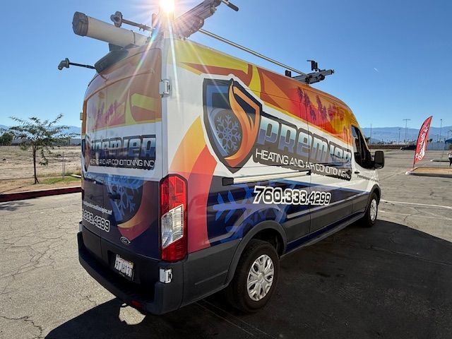 White van with company branding parked outdoors; 