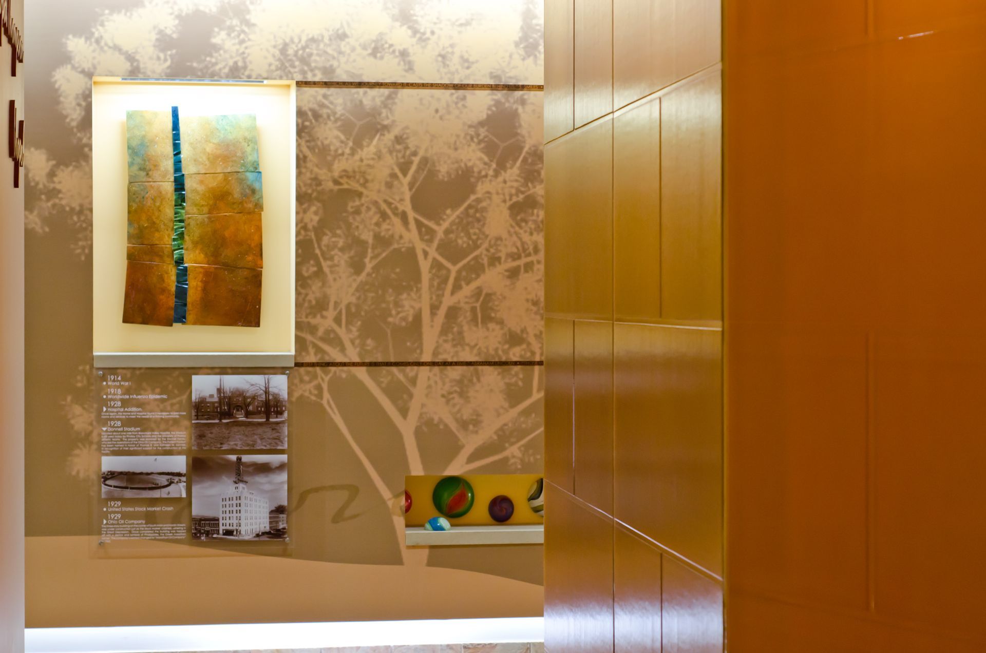 Elegant hallway with abstract art, beige patterned walls, and warm wood paneling