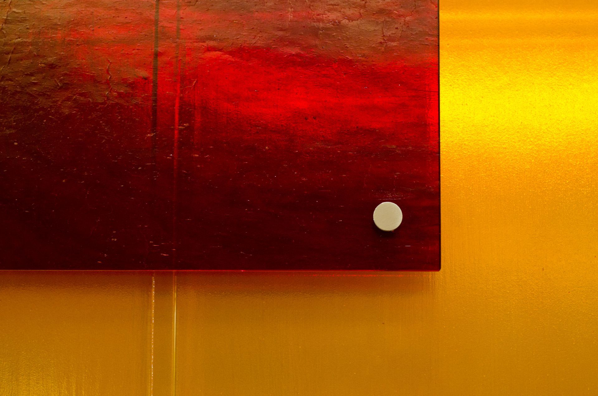 Abstract red and orange wall art with a small white dot near the lower right corner