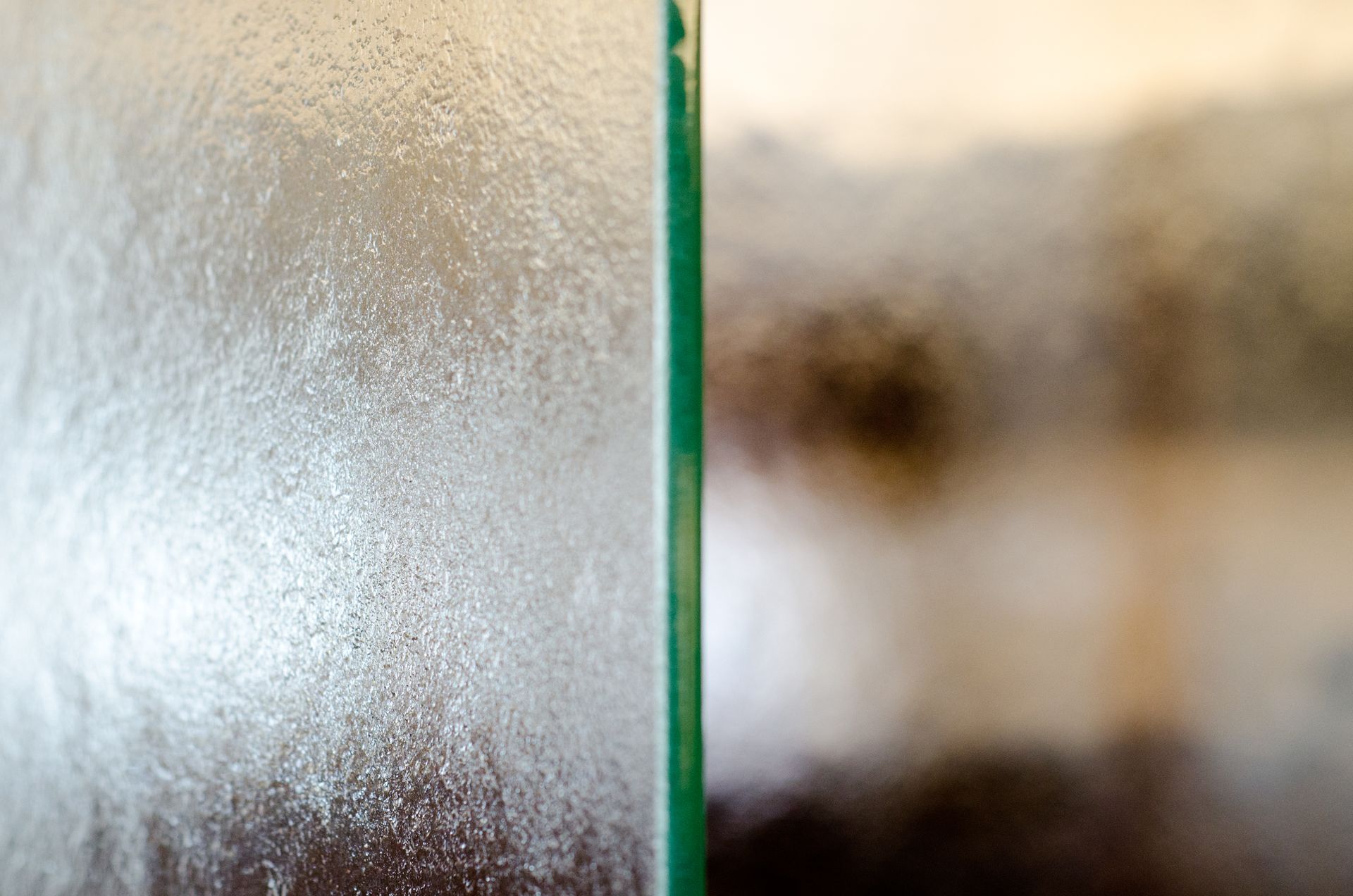 Frosted glass panel beside a blurred brown and white background