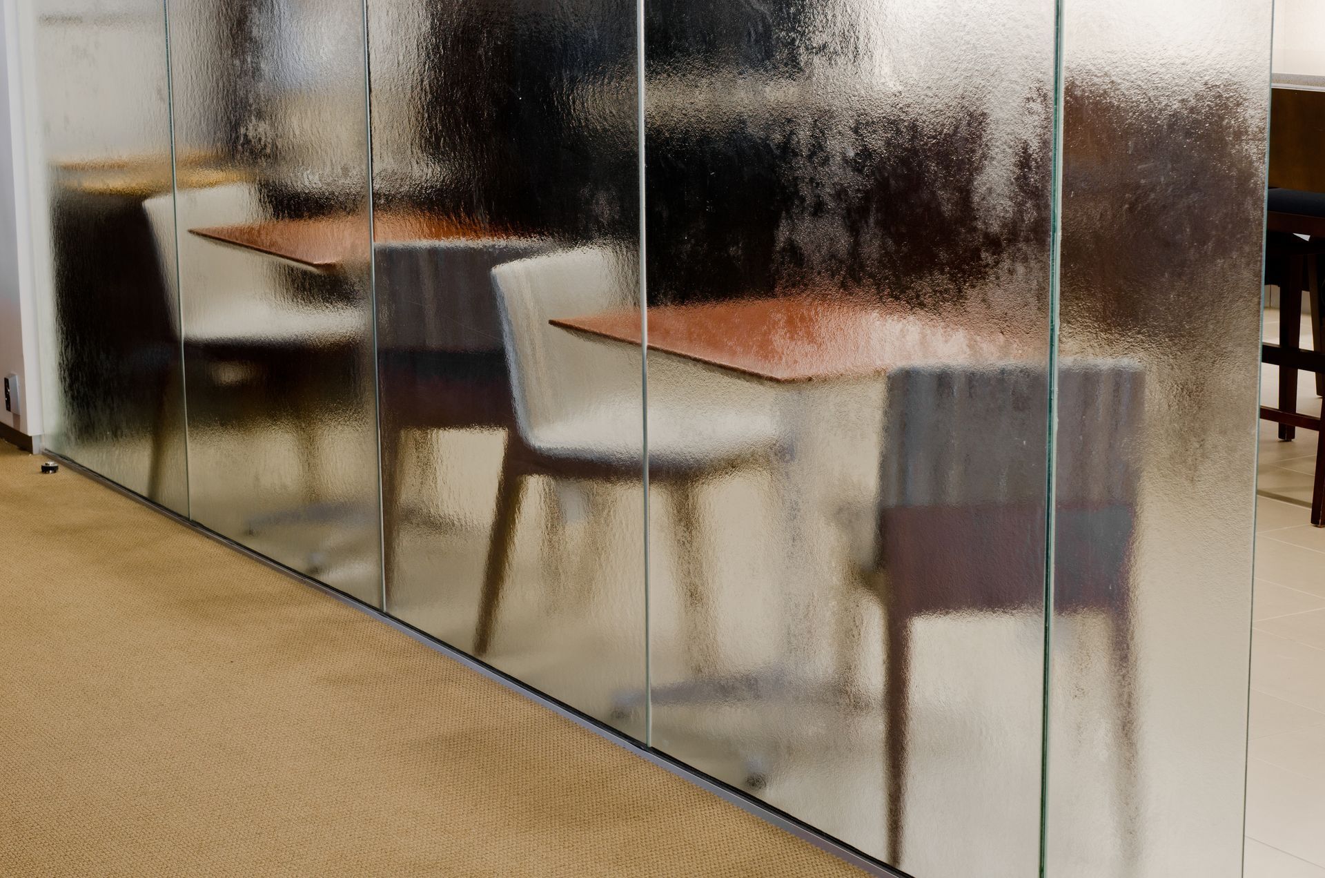 Café seating with tables and chairs behind frosted glass partitions