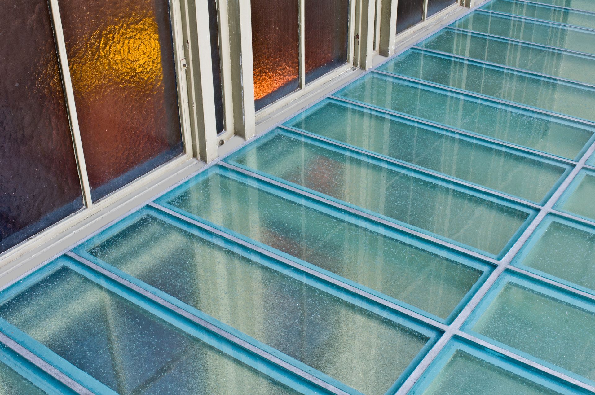 Blue glass rooftop panels beside tall windows