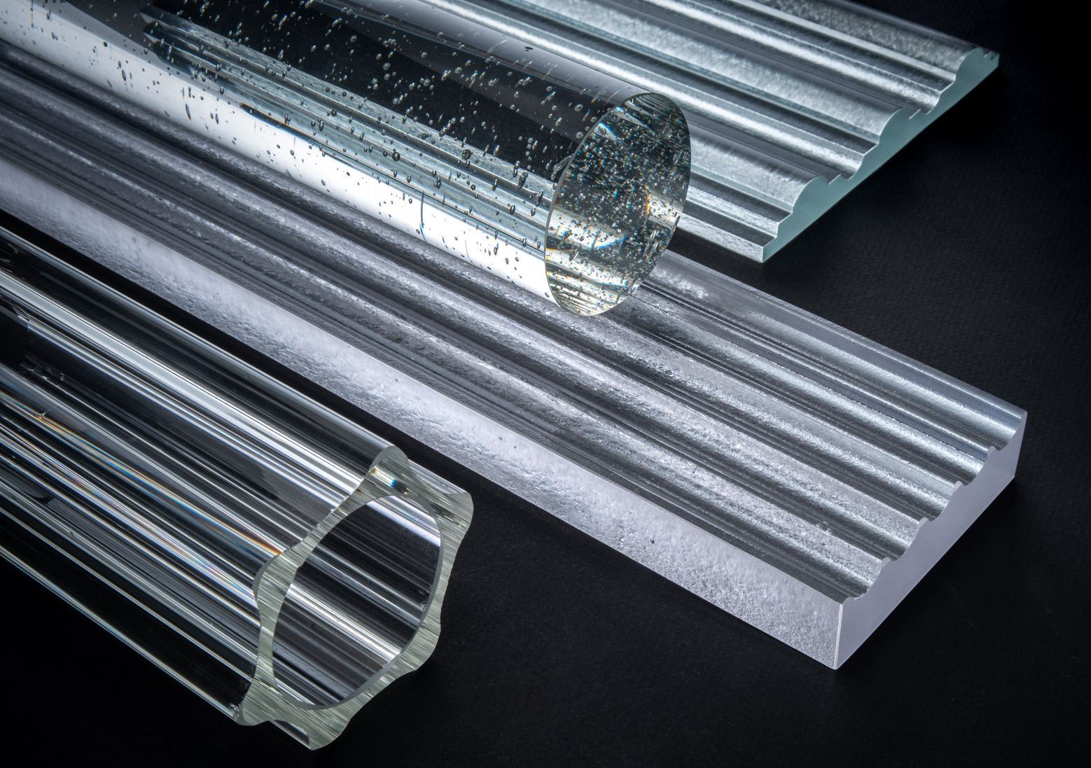 A close up of three different types of cast glass on a black surface