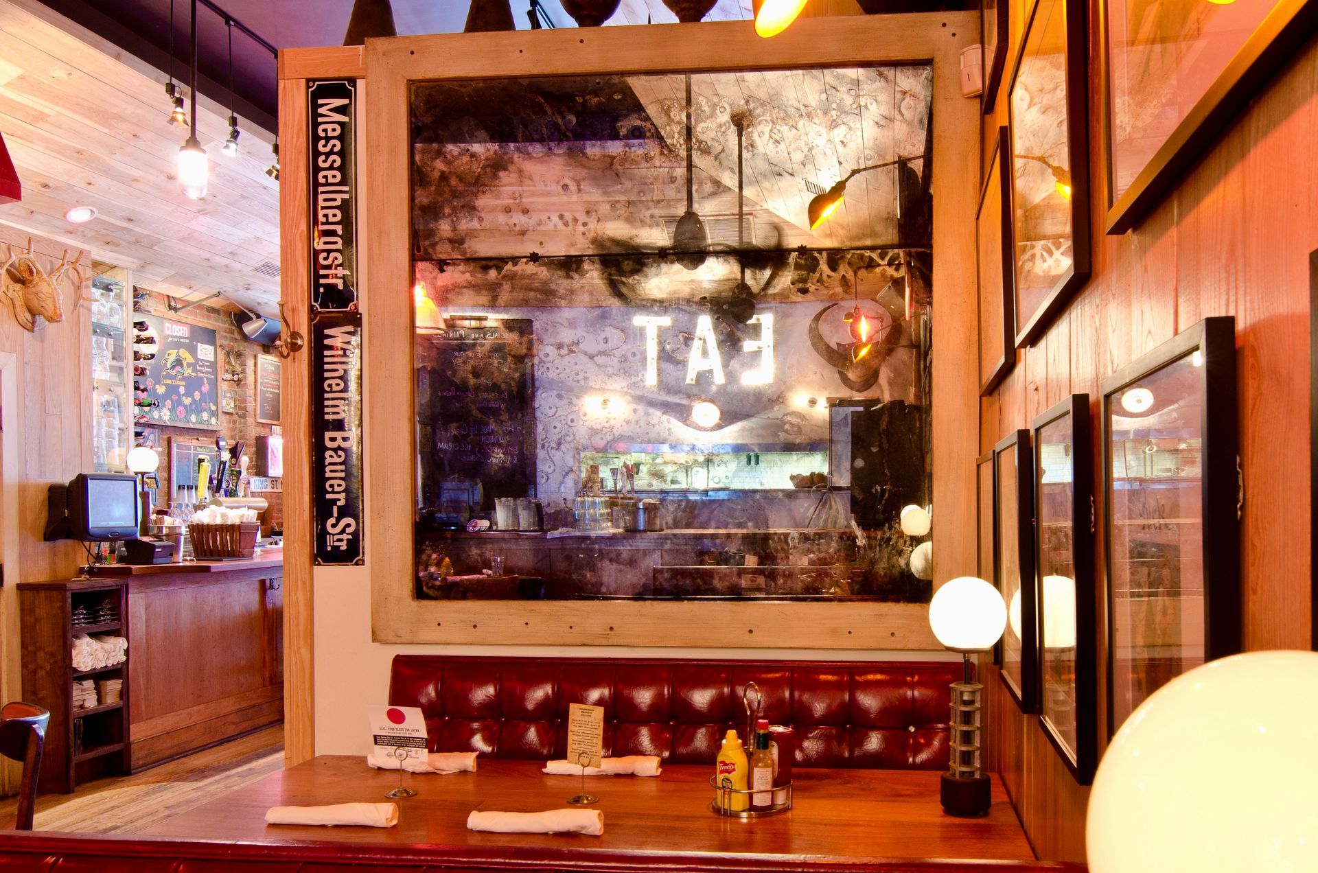 A restaurant with a framed antique mirror 
