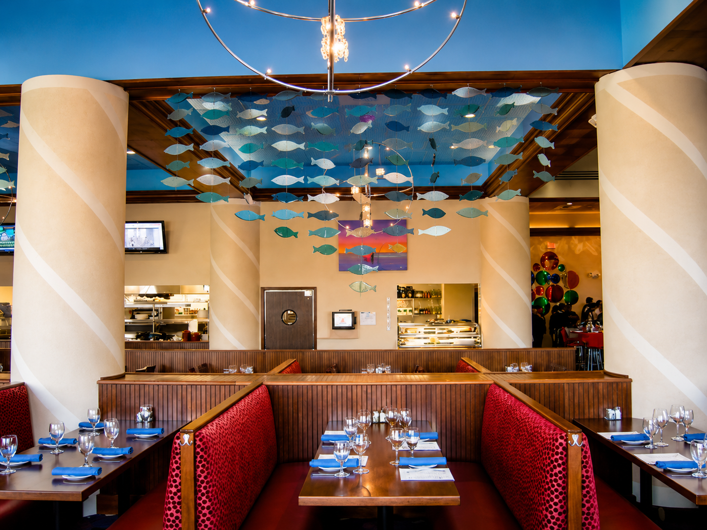 Colorful restaurant booth seating with a decorated ceiling and warm lighting