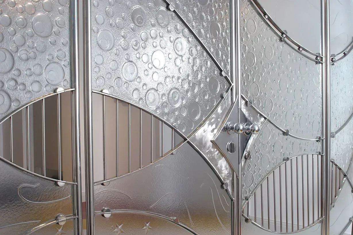 Textured glass panel with bubbles, lines, and polished metal frame.