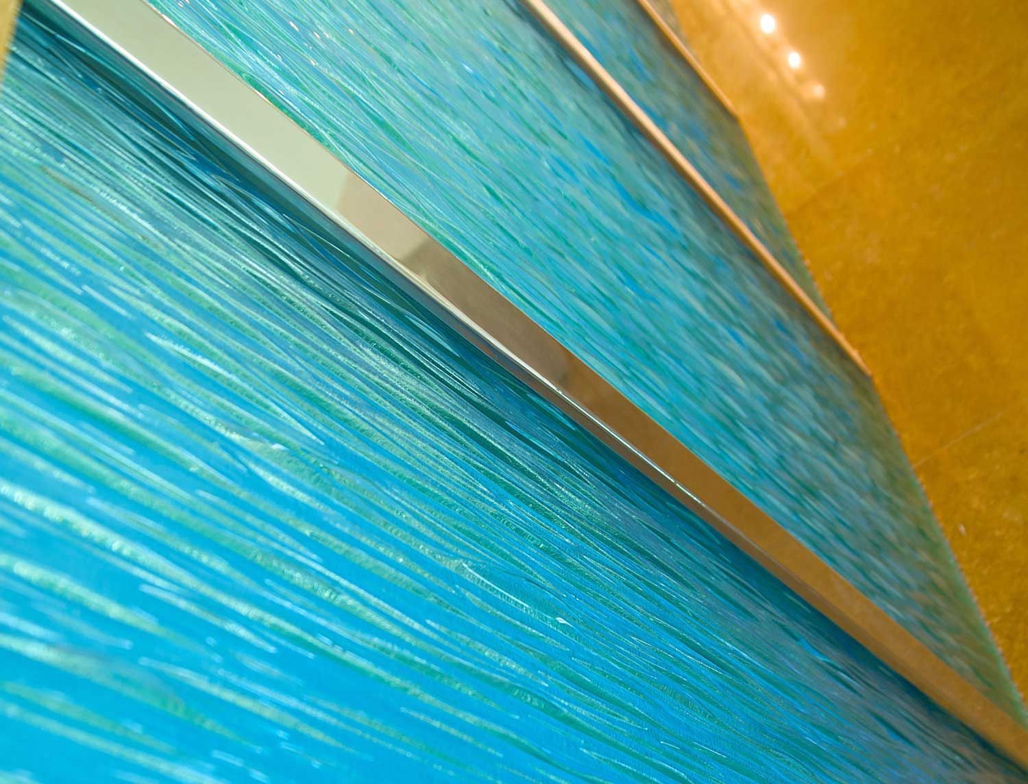 Close-up of blue paper fans with a gold fold against an orange background