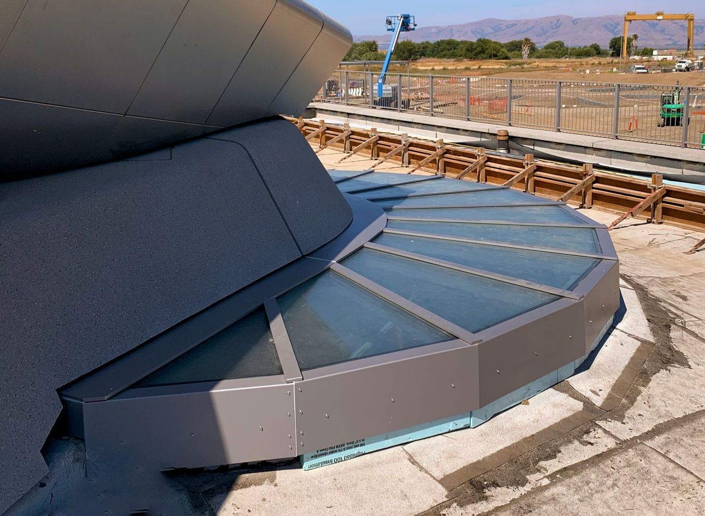 A circular structure with walkable glass skylyights under construction.