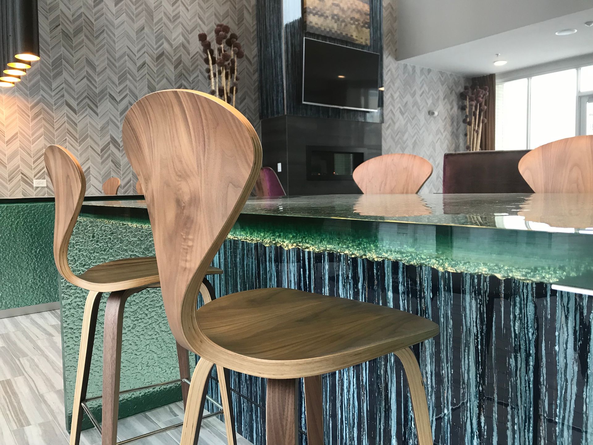 A wooden chair is sitting next to a glass counter in a kitchen.