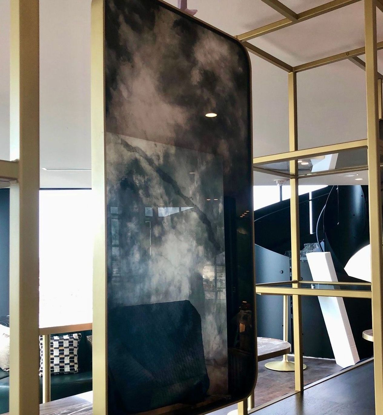 A large antique mirror is hanging on a wall in a room