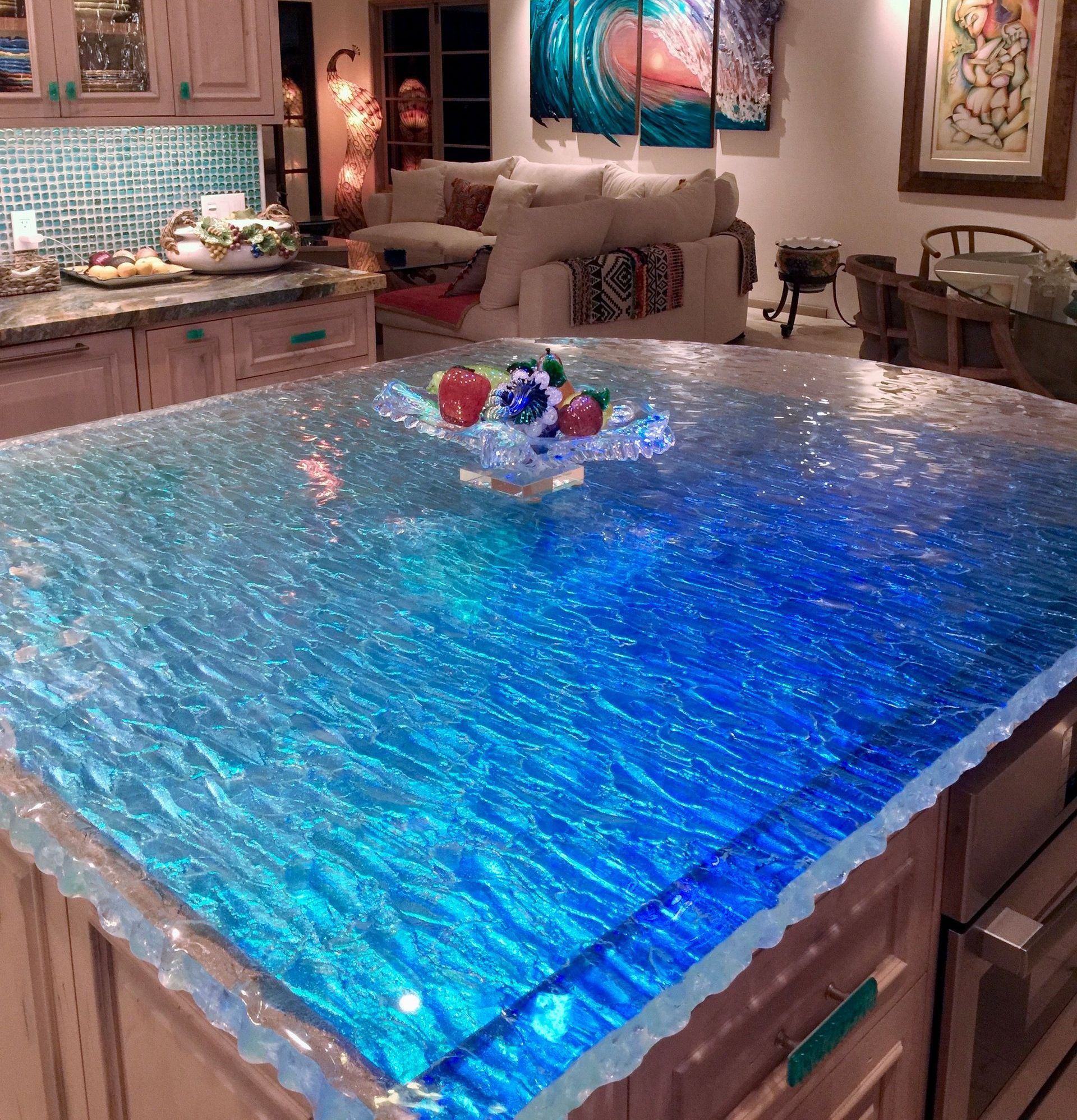 A glass kitchen island with a bowl of fruit on it