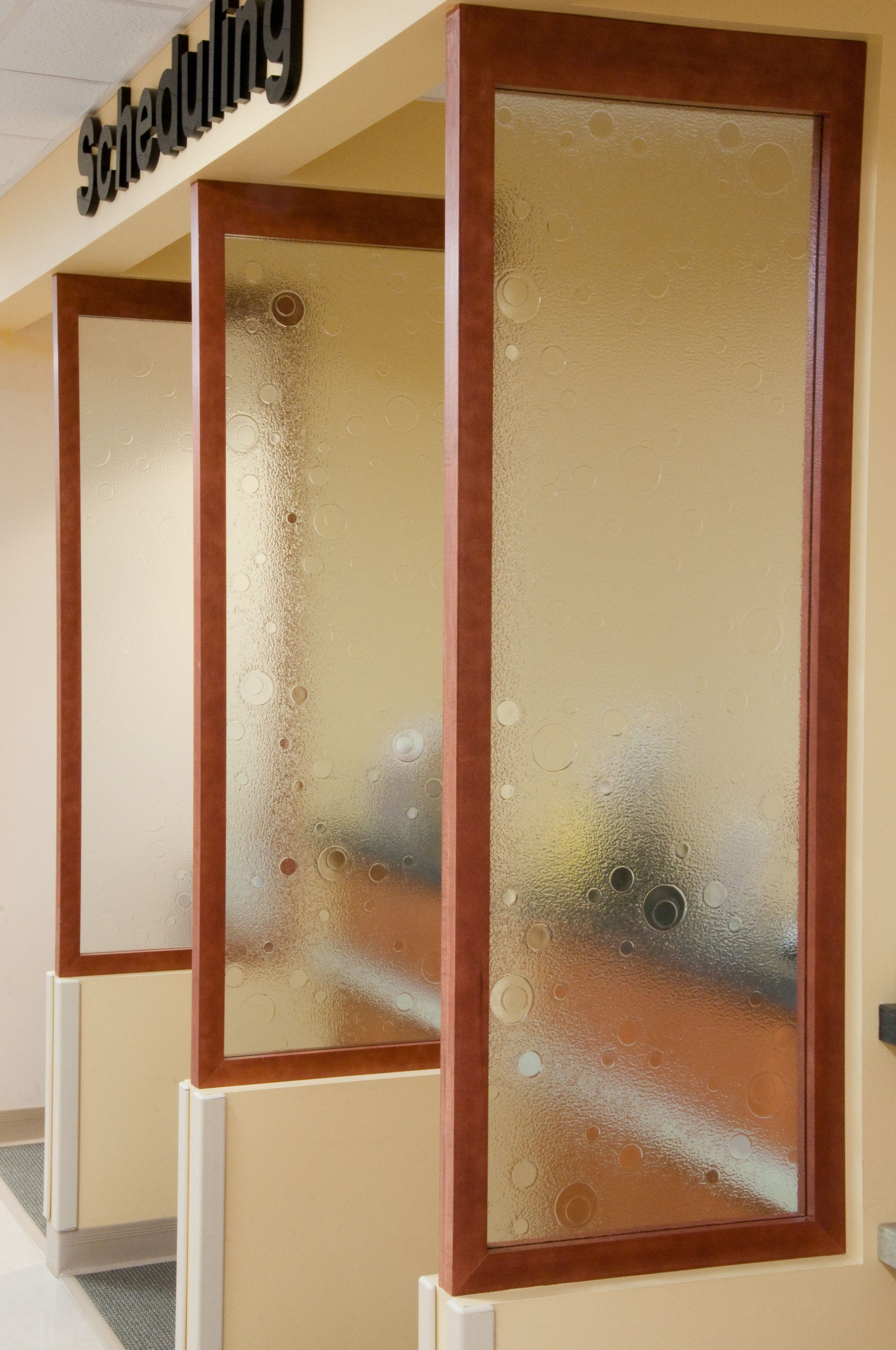 Wood-framed frosted glass service windows in a hallway or office interior