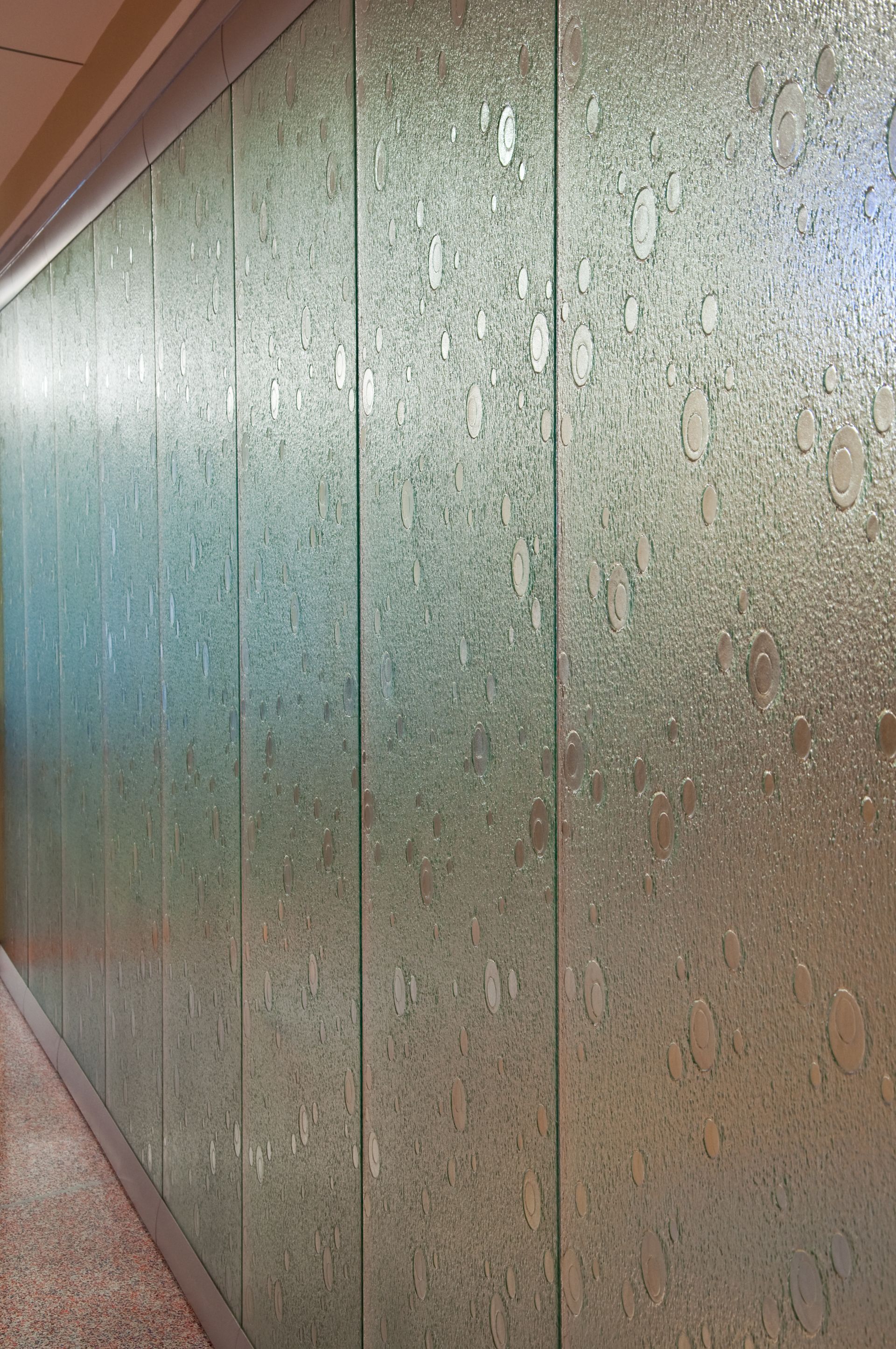 Textured green wall with vertical panel seams and a wooden trim edge