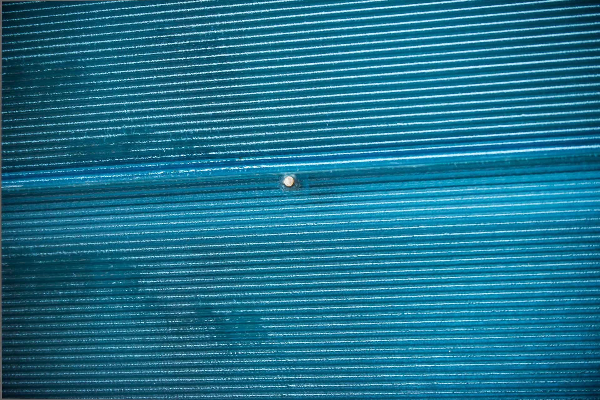 Blue textured surface with a small white speck near the center