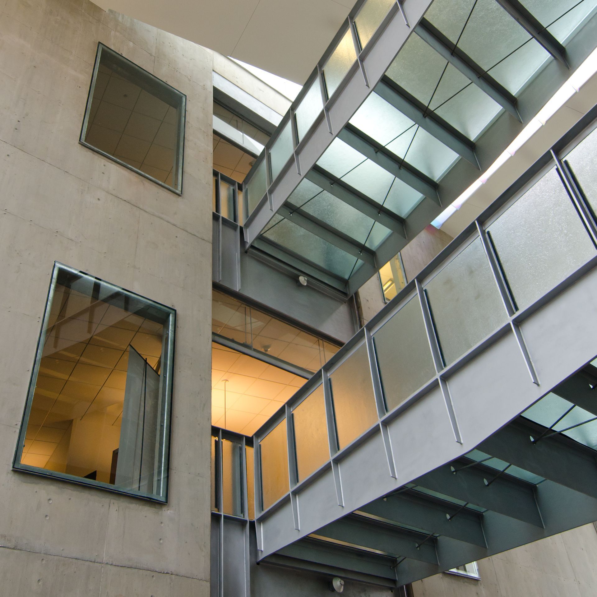 Modern building atrium with glass skybridges, concrete walls, and large windows