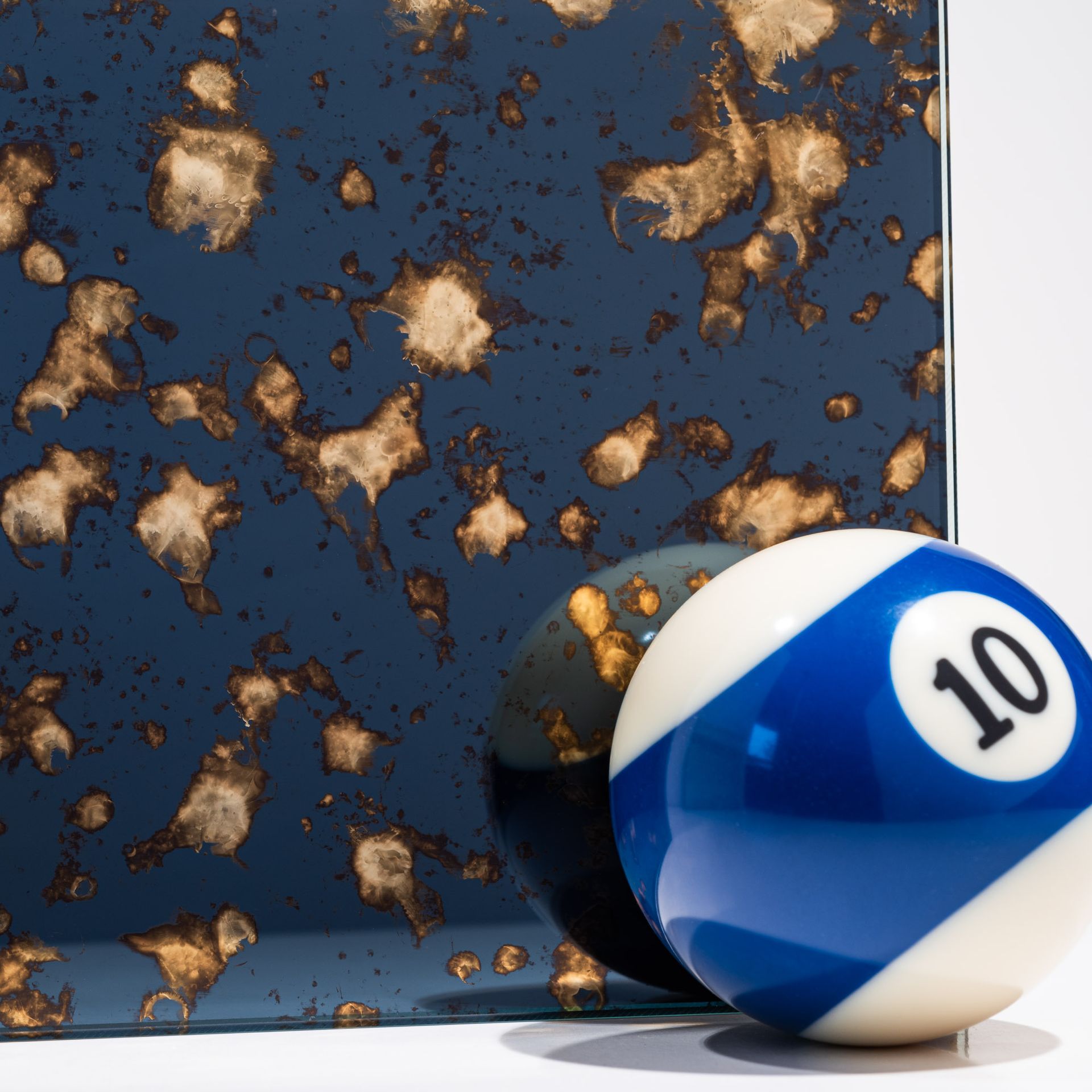 Billiard ball in front of a gold and blue antique mirror finish Billiard ball in front of a gold and blue antique mirror finish