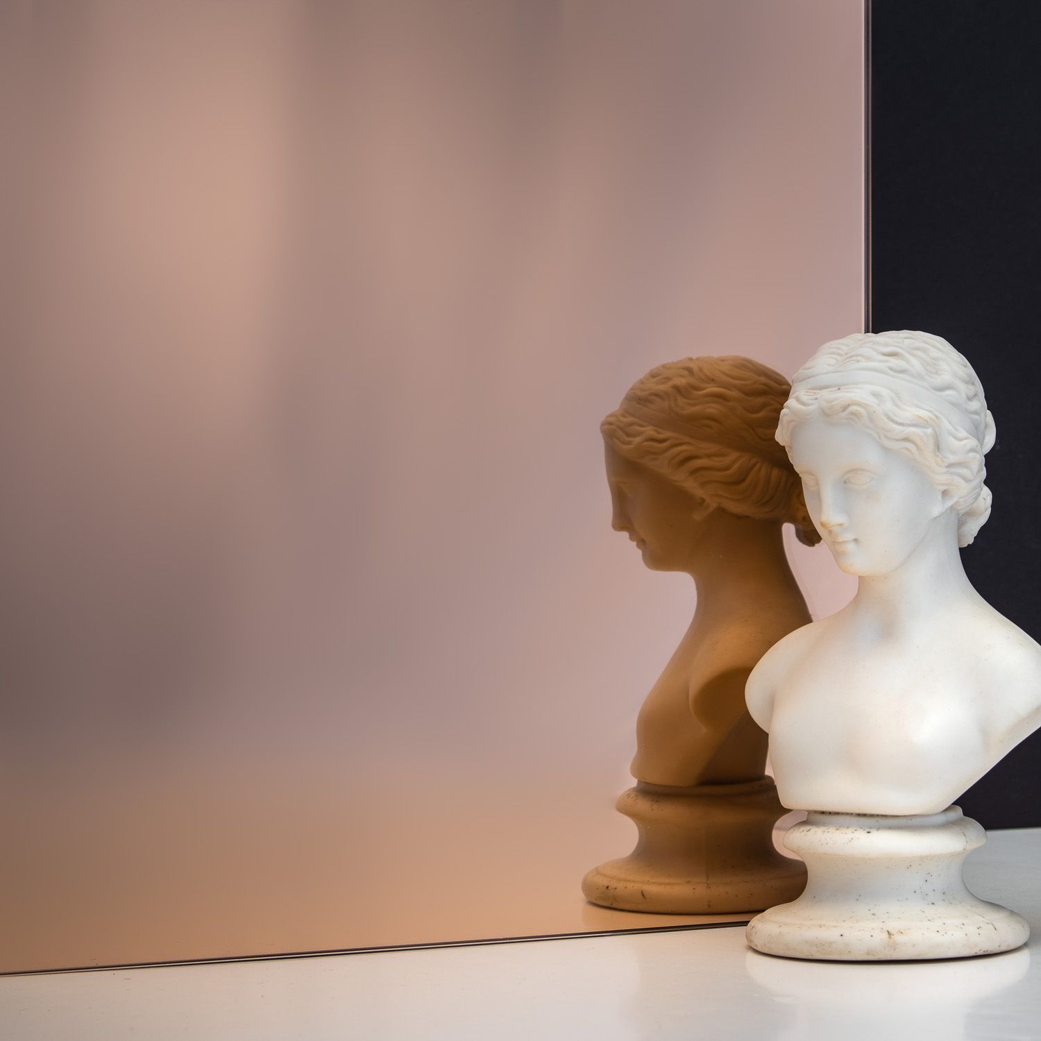 TCG Glass MirrorHues™ pink glass with a white bust reflecting in it