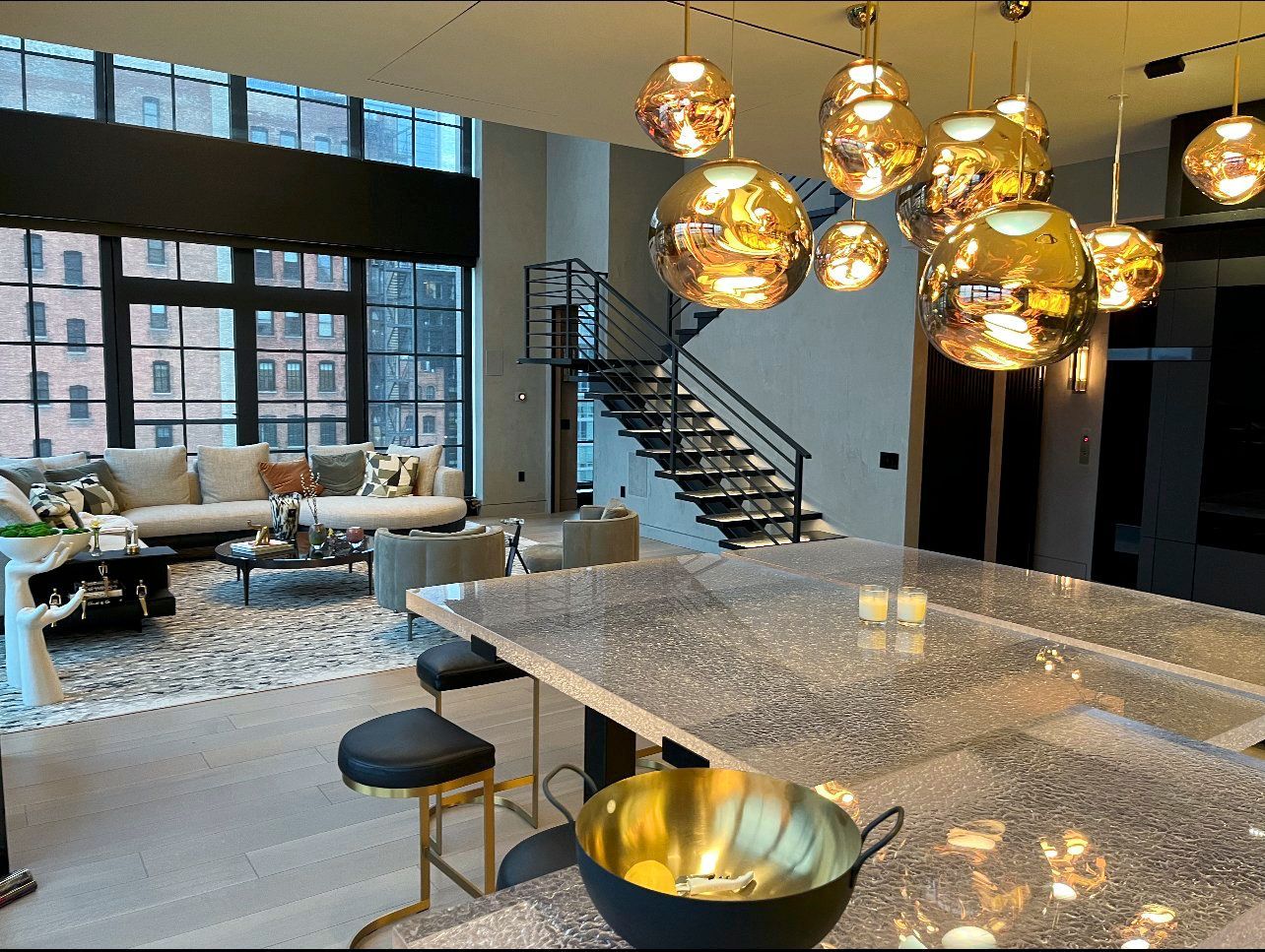 A living room with a staircase and a bowl on the glass counter