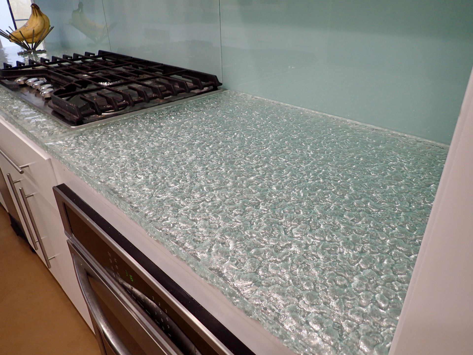 A kitchen with a stove top oven and a glass counter top