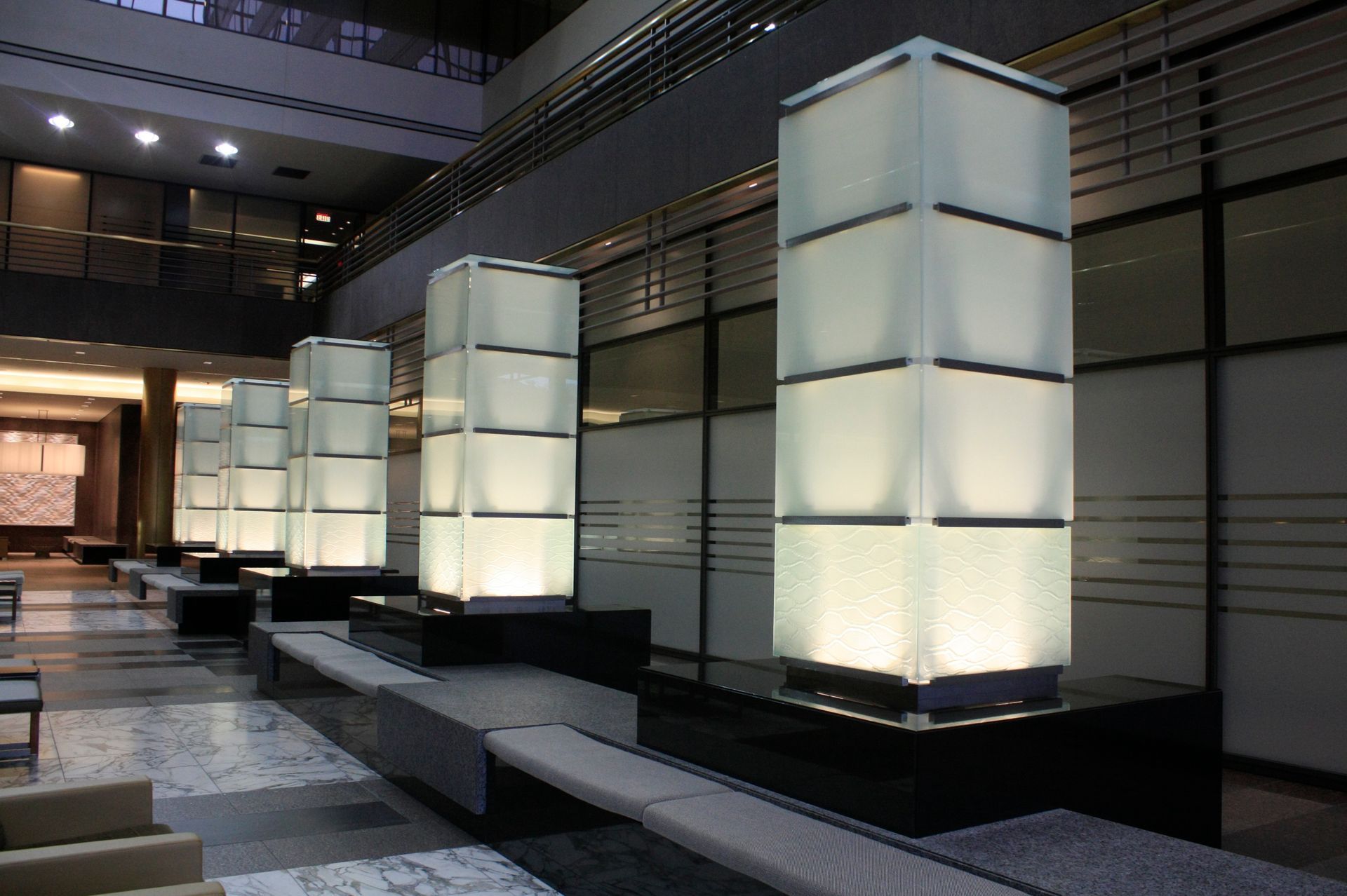Modern lobby with lit, rectangular columns and built-in benches.