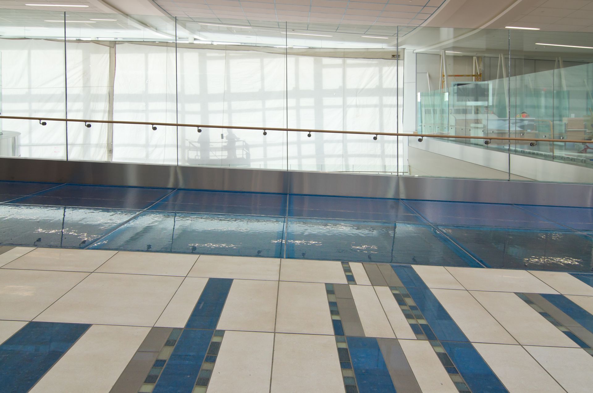 Indoor swimming pool with blue lane markings and glass walls