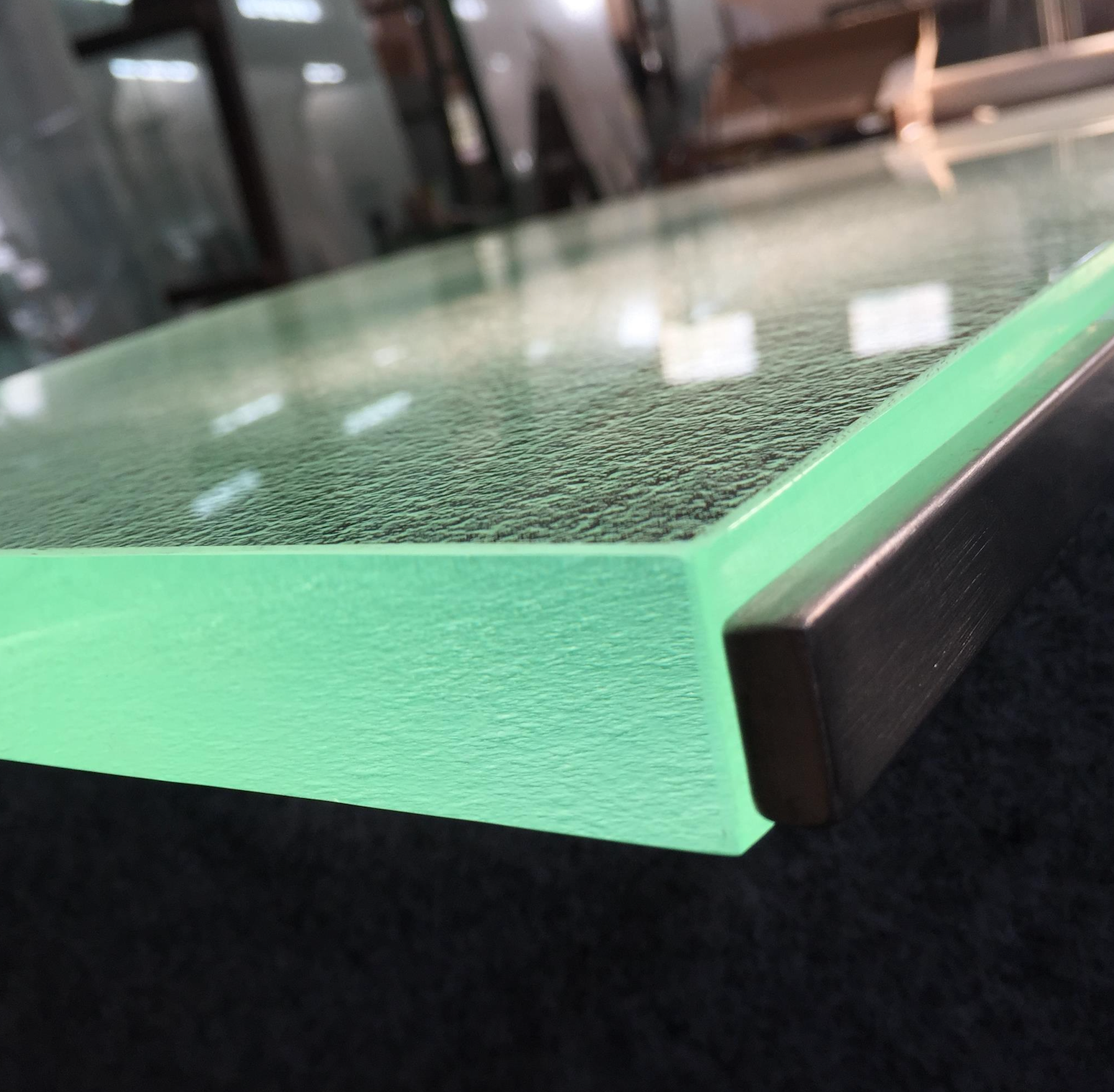 A glass counter top with a green molding is sitting on a table.
