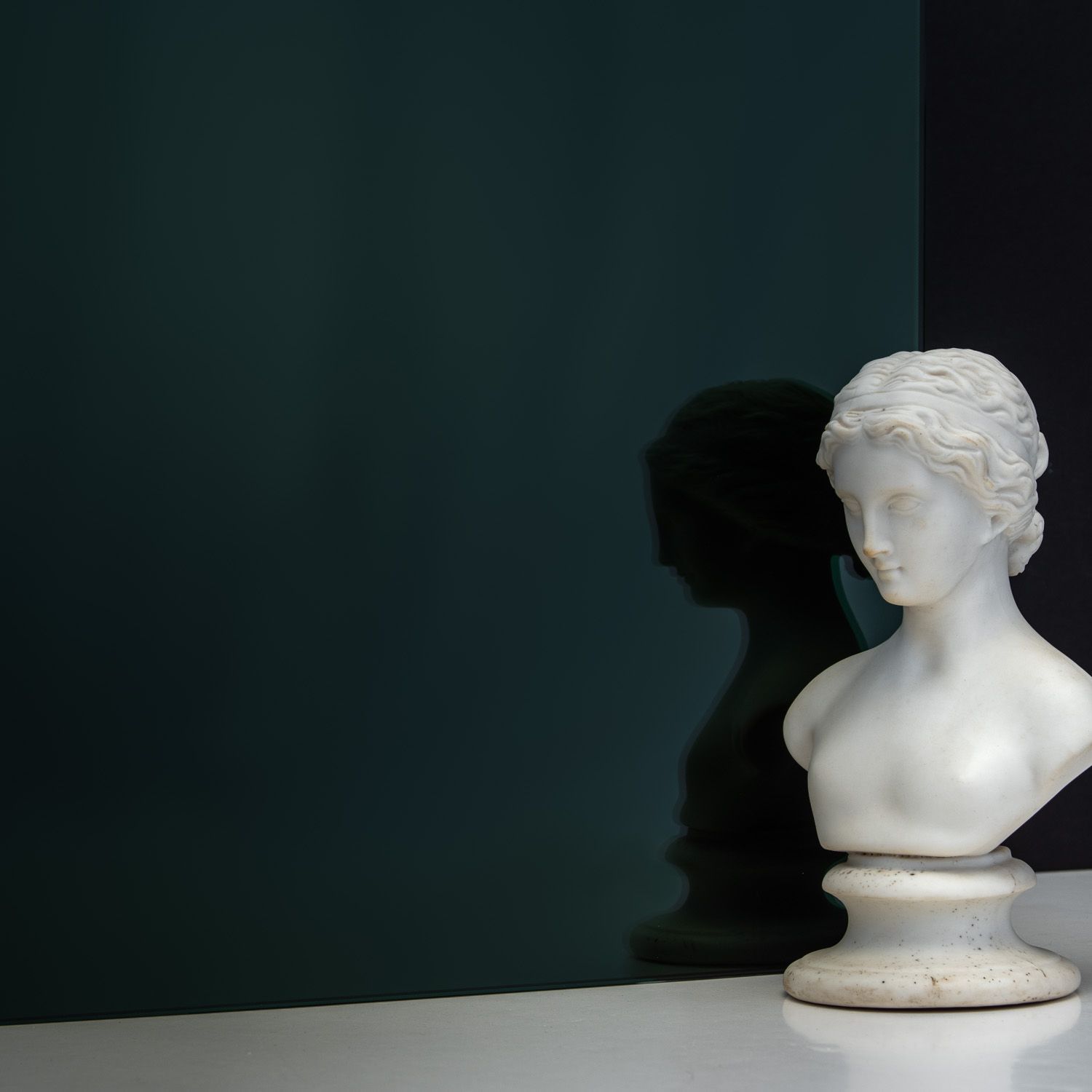 TCG Glass MirrorHues™ black silver glass with a white bust reflecting in it