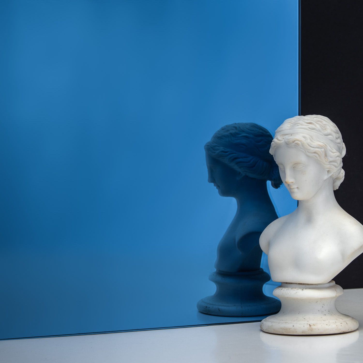 TCG Glass MirrorHues™ gem blue glass with a white bust reflecting in it
