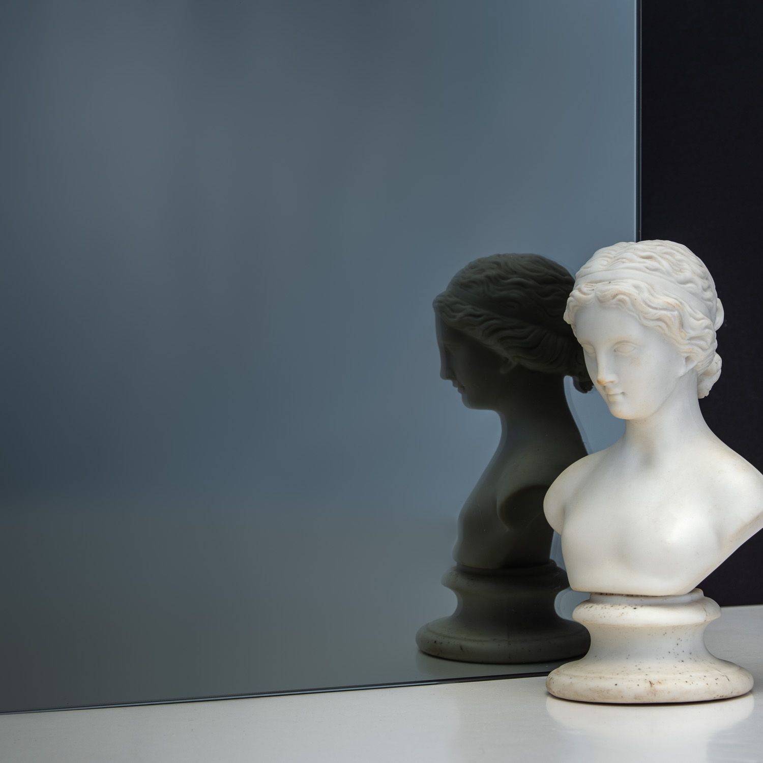 TCG Glass MirrorHues™ euro grey glass with a white bust reflecting in it