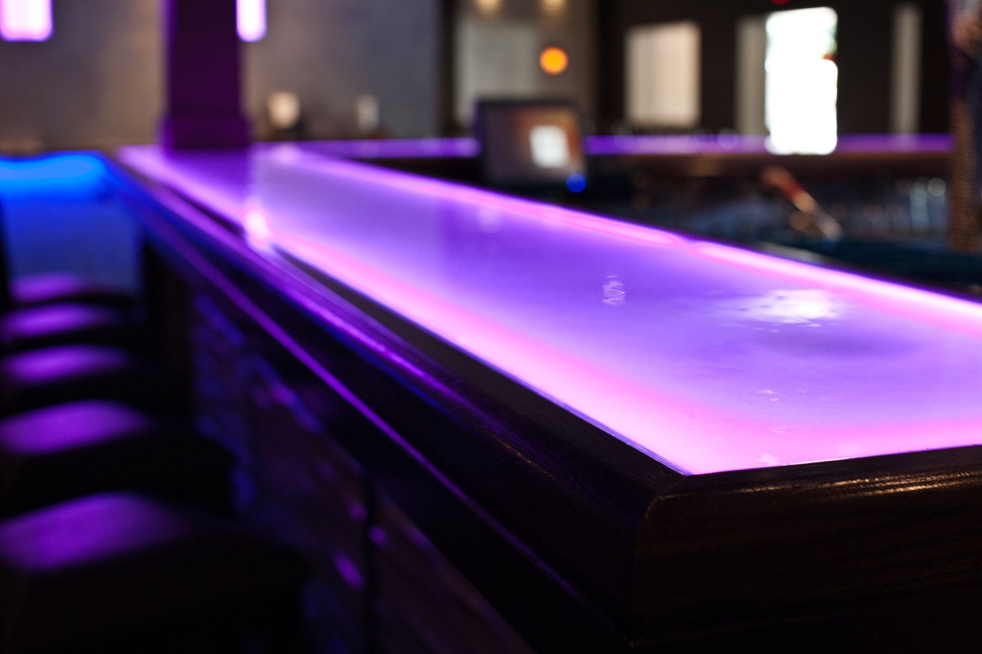 A glass countertop with integrated LED lights glowing purple. A glass countertop with integrated LED lights glowing purple.