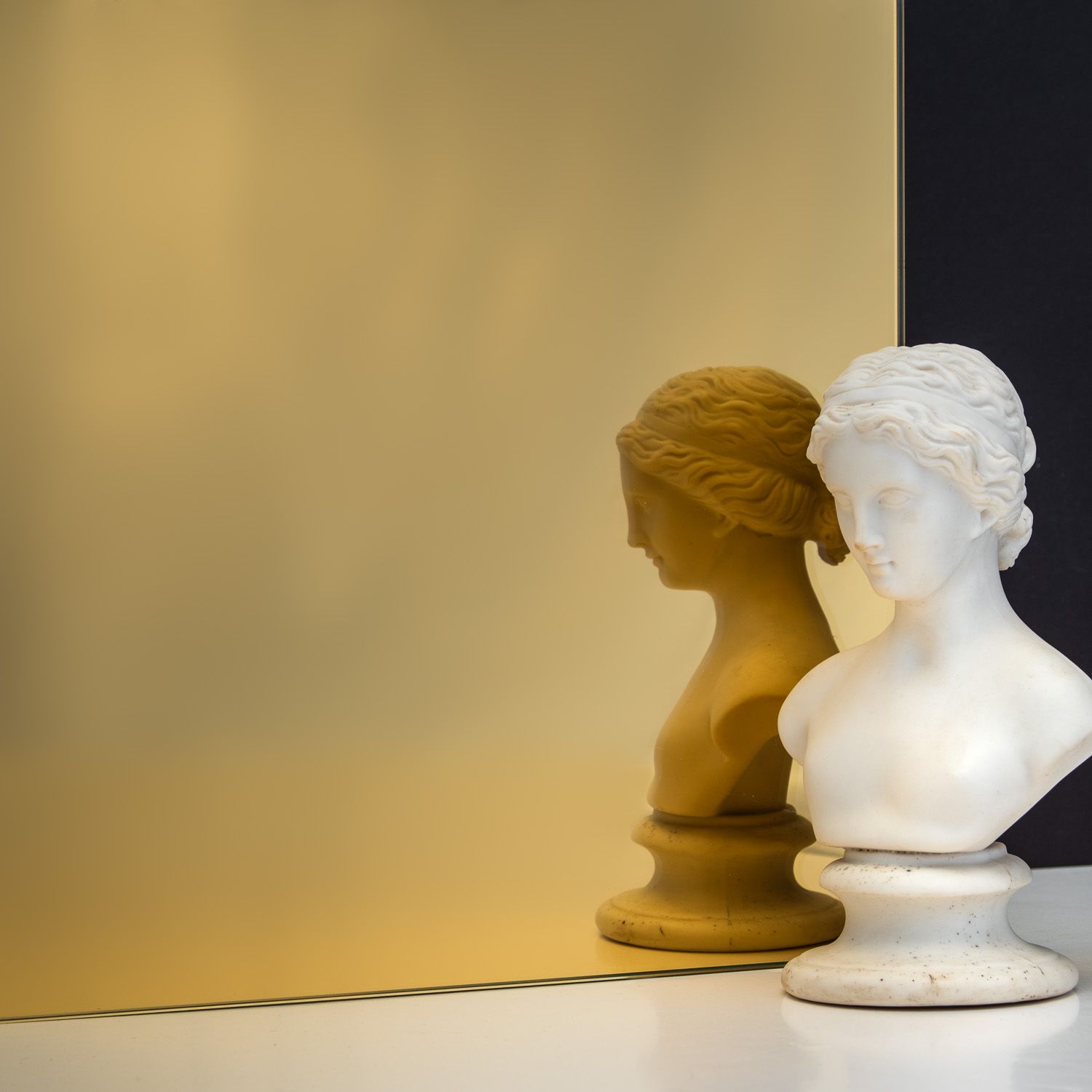 TCG Glass MirrorHues™ gold glass with a white bust reflecting in it