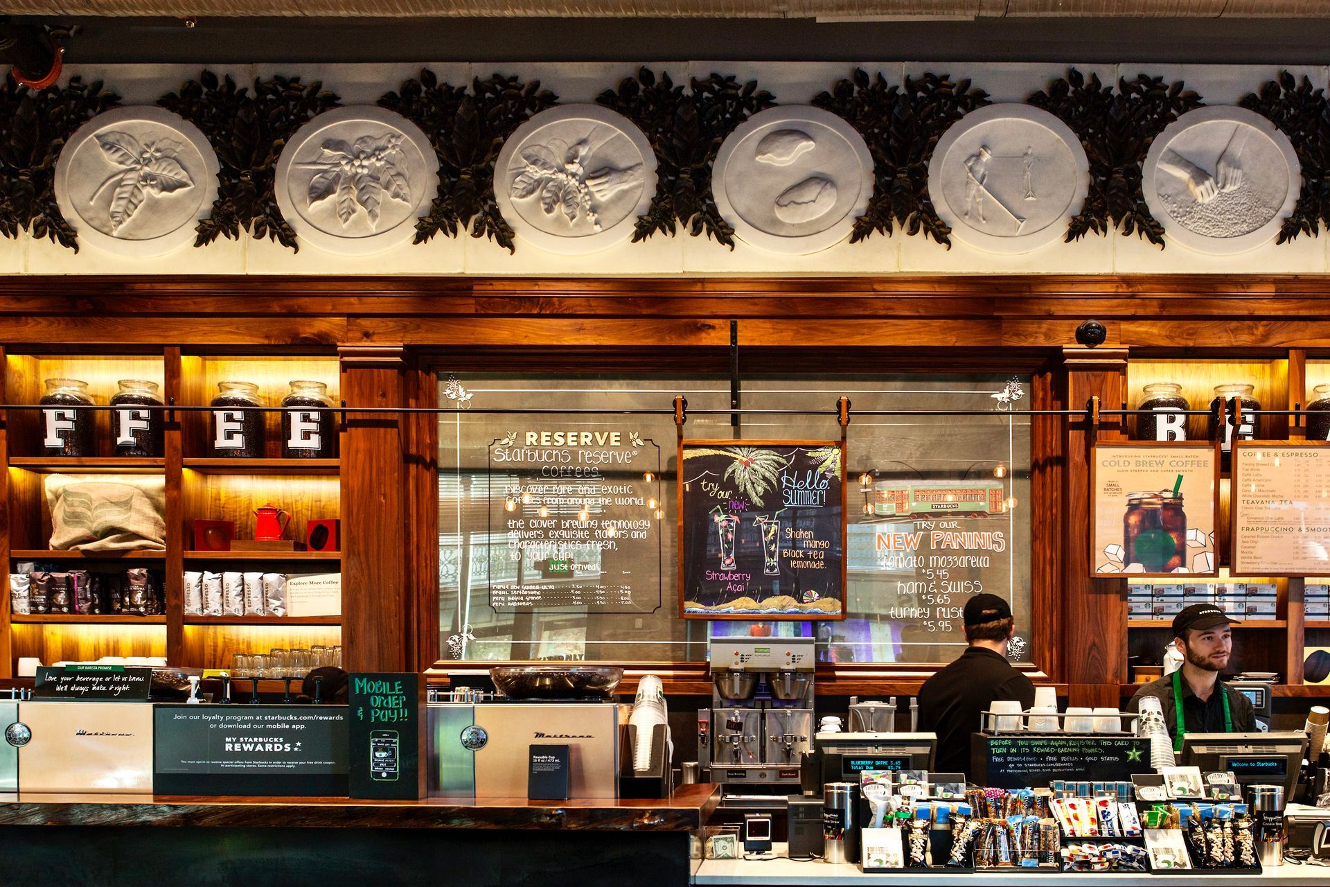 A man is standing behind a counter in a restaurant.