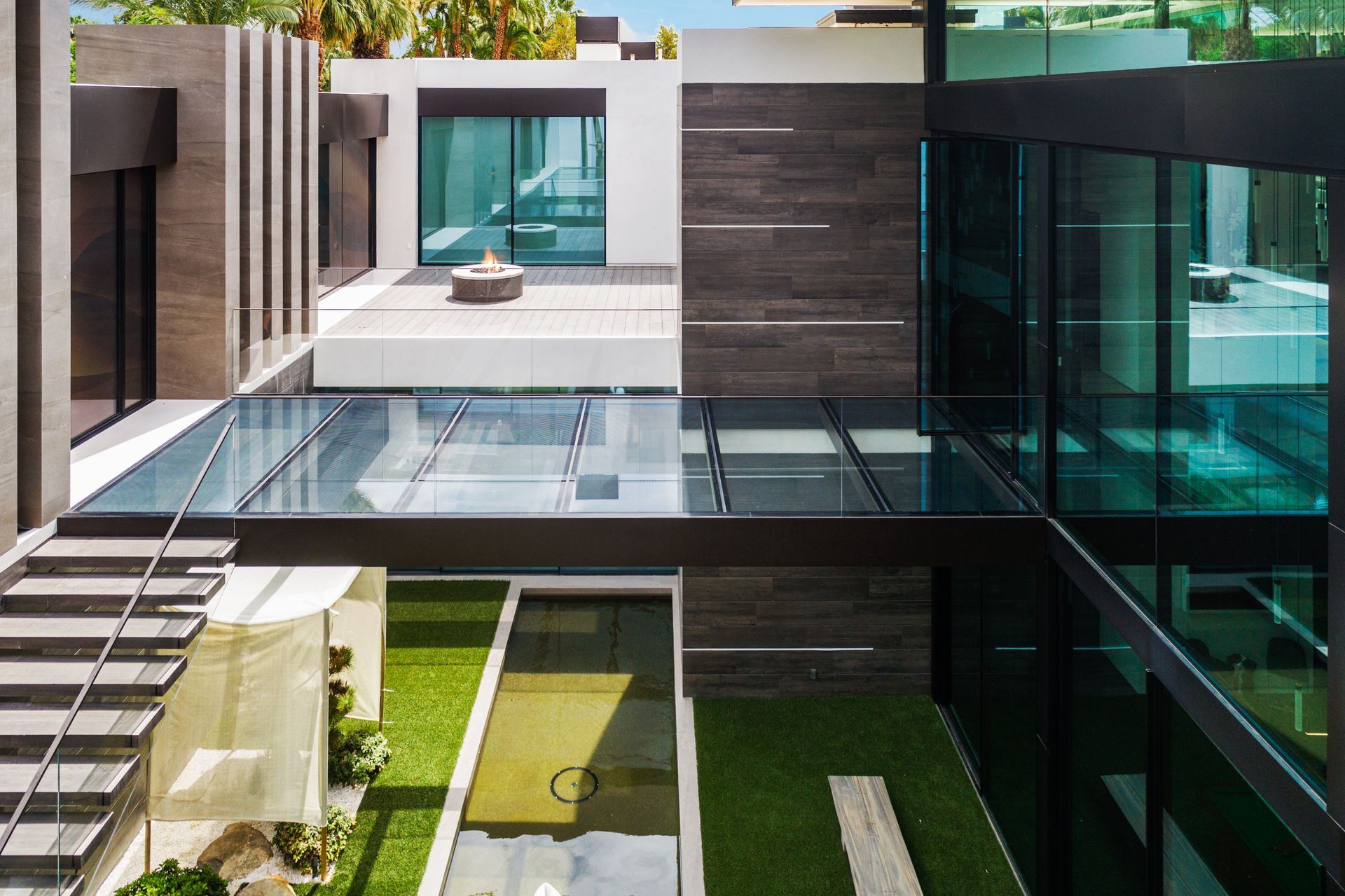 Modern house with glass walkways, central courtyard, and exterior stairs.