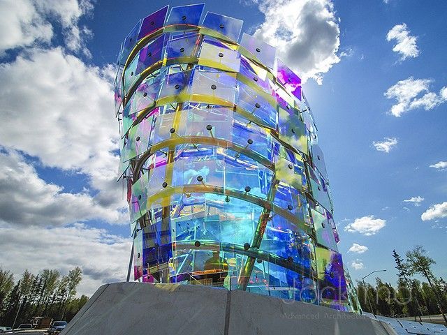 A sculpture made of dichroic glass is sitting on top of a concrete base.