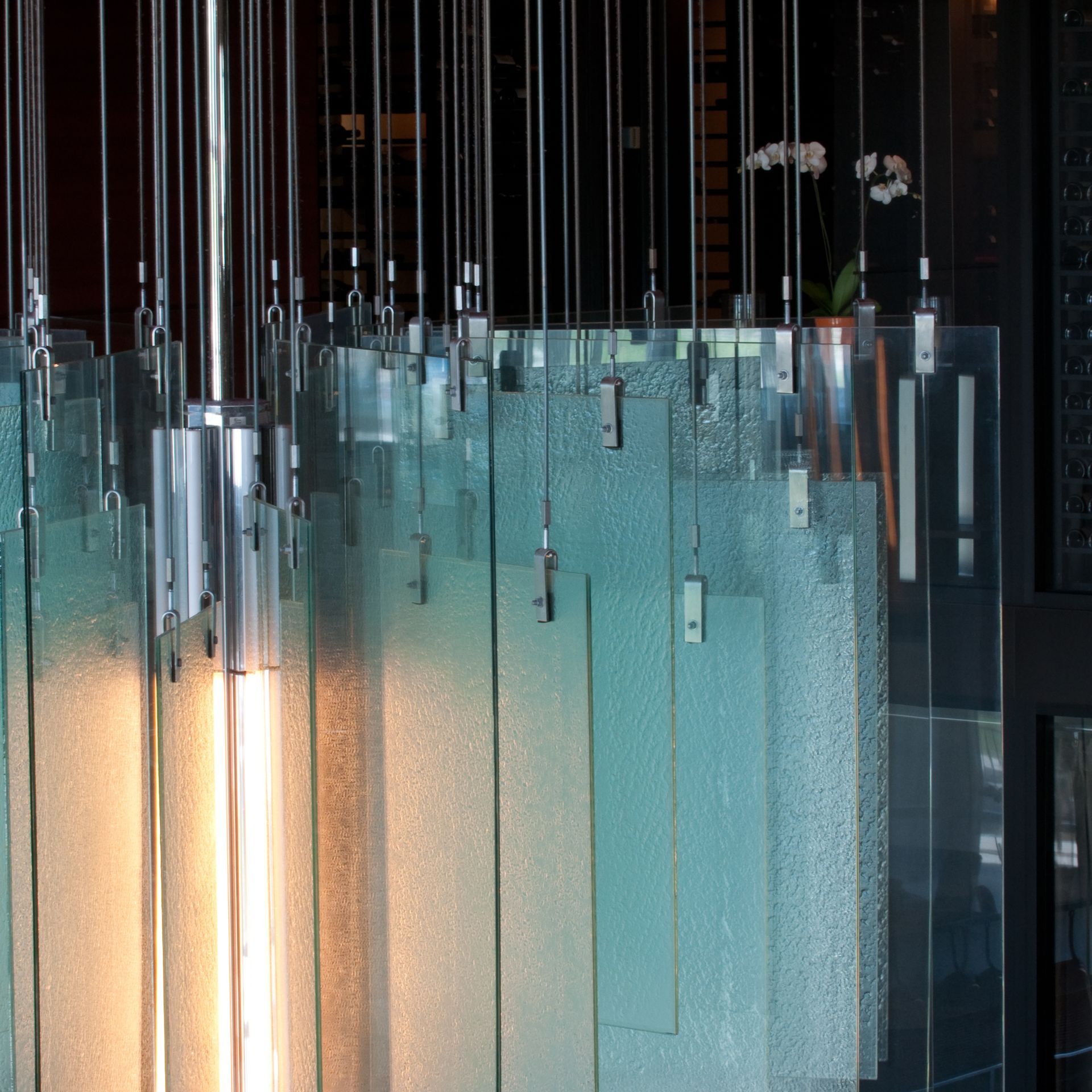 Glass pendant lights hanging in a modern interior, softly glowing in warm and blue tones