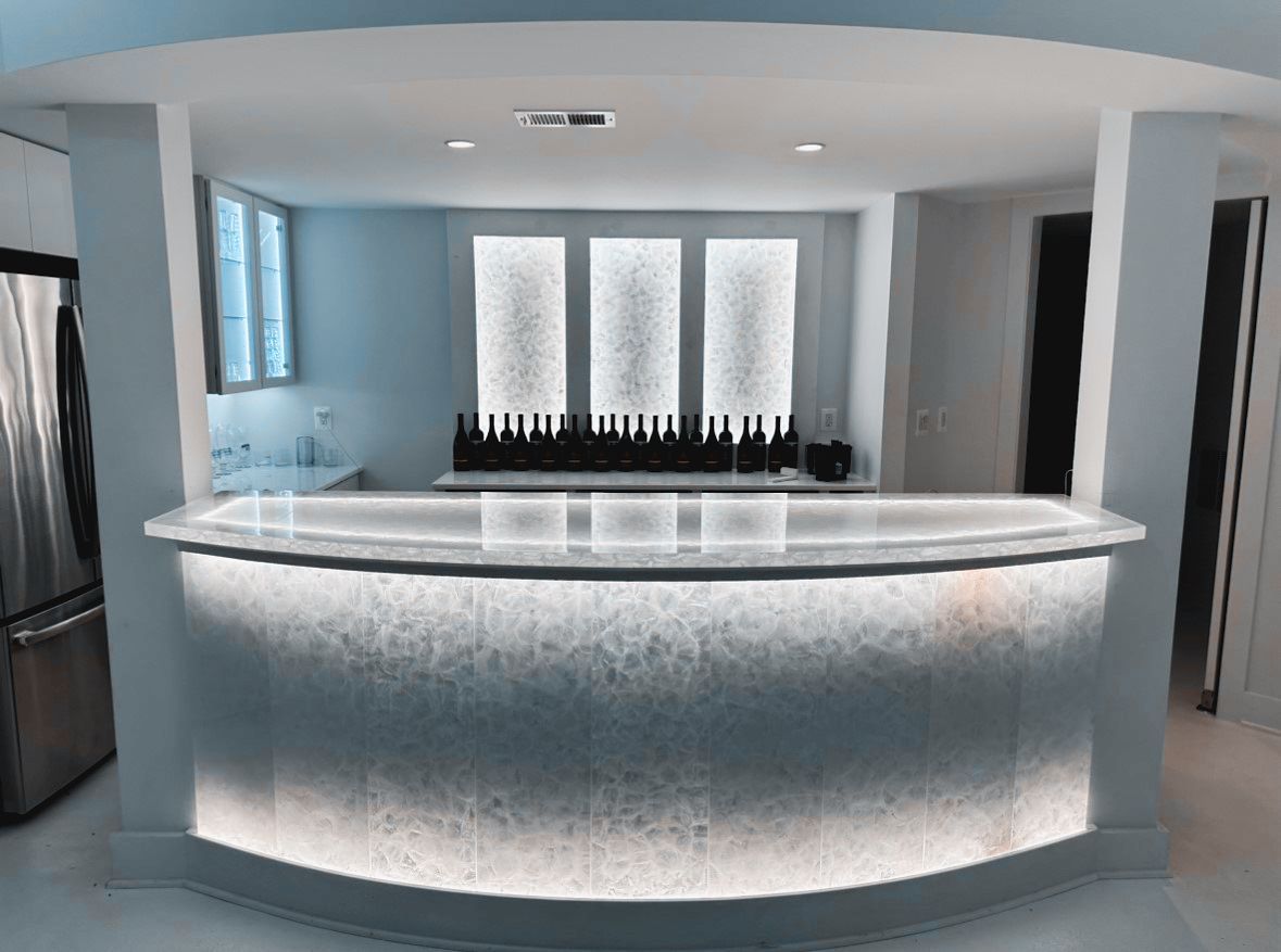 A kitchen with a curved bar and a refrigerator.