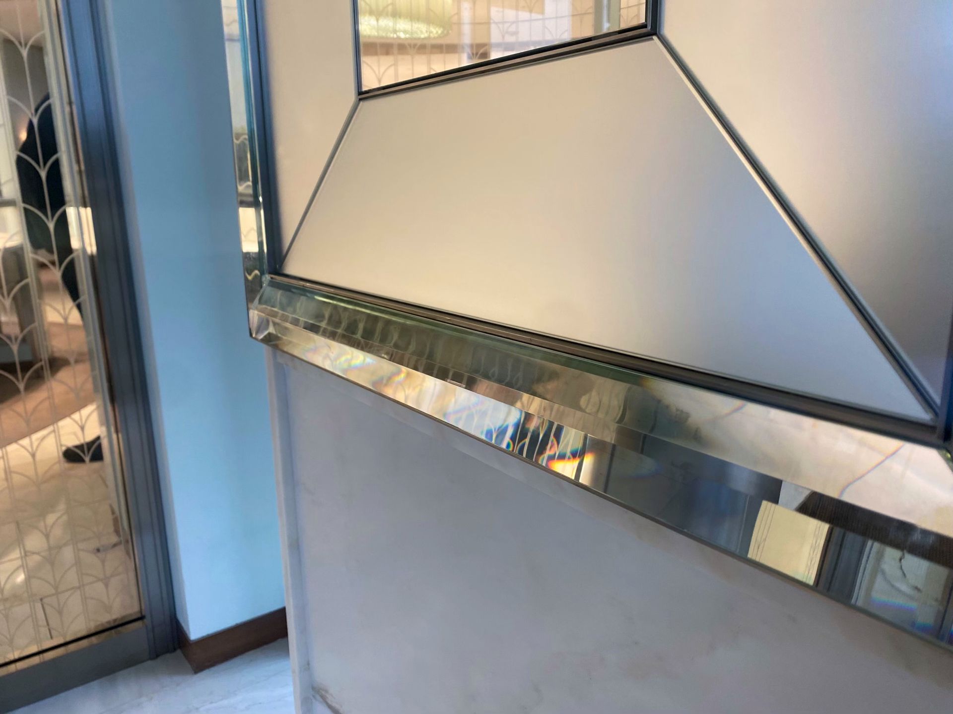 A close up of a glass moulding frame on a wall in a room.