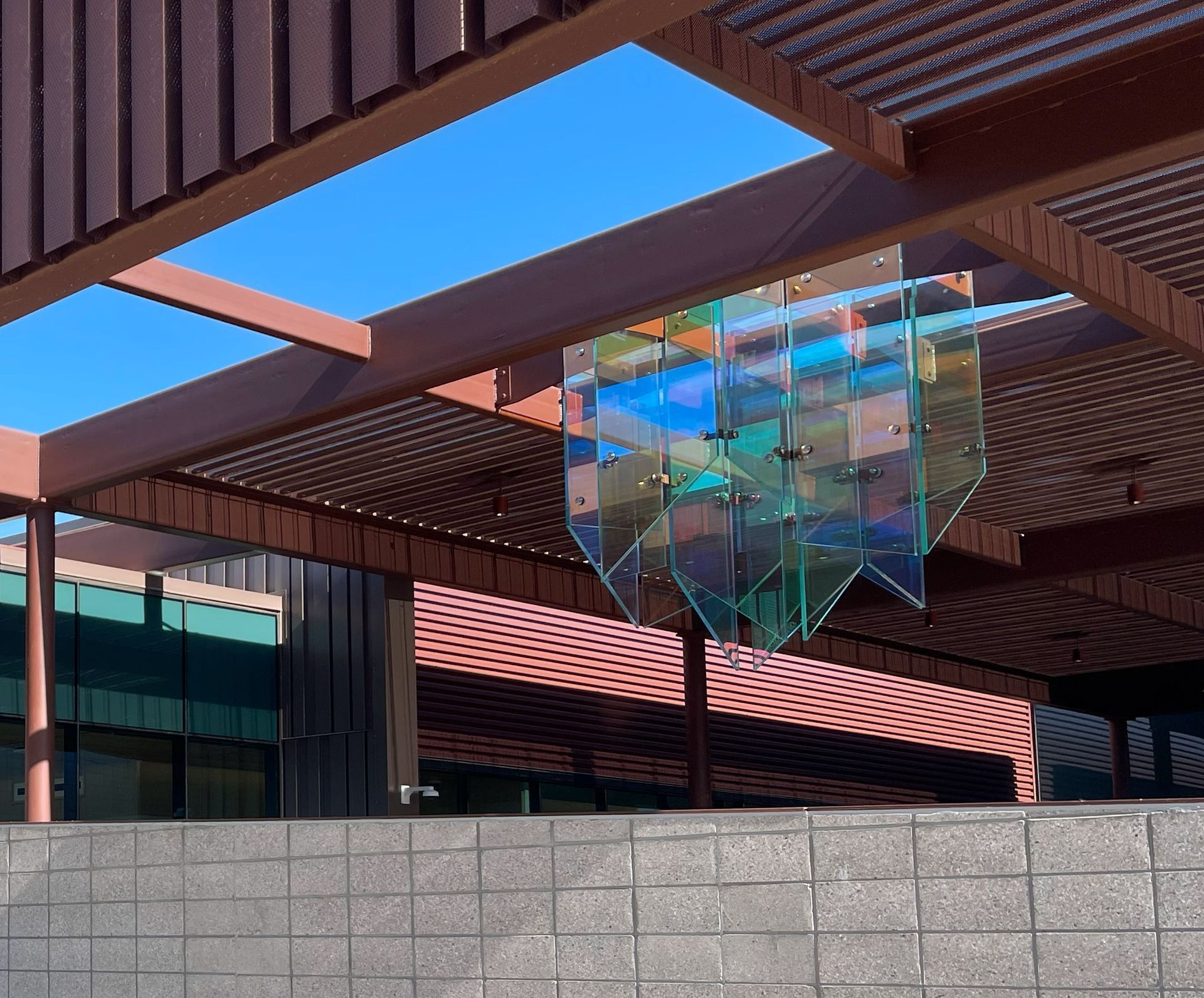 A sculpture made of dichroic glass is hanging from the ceiling of the Tucson museum