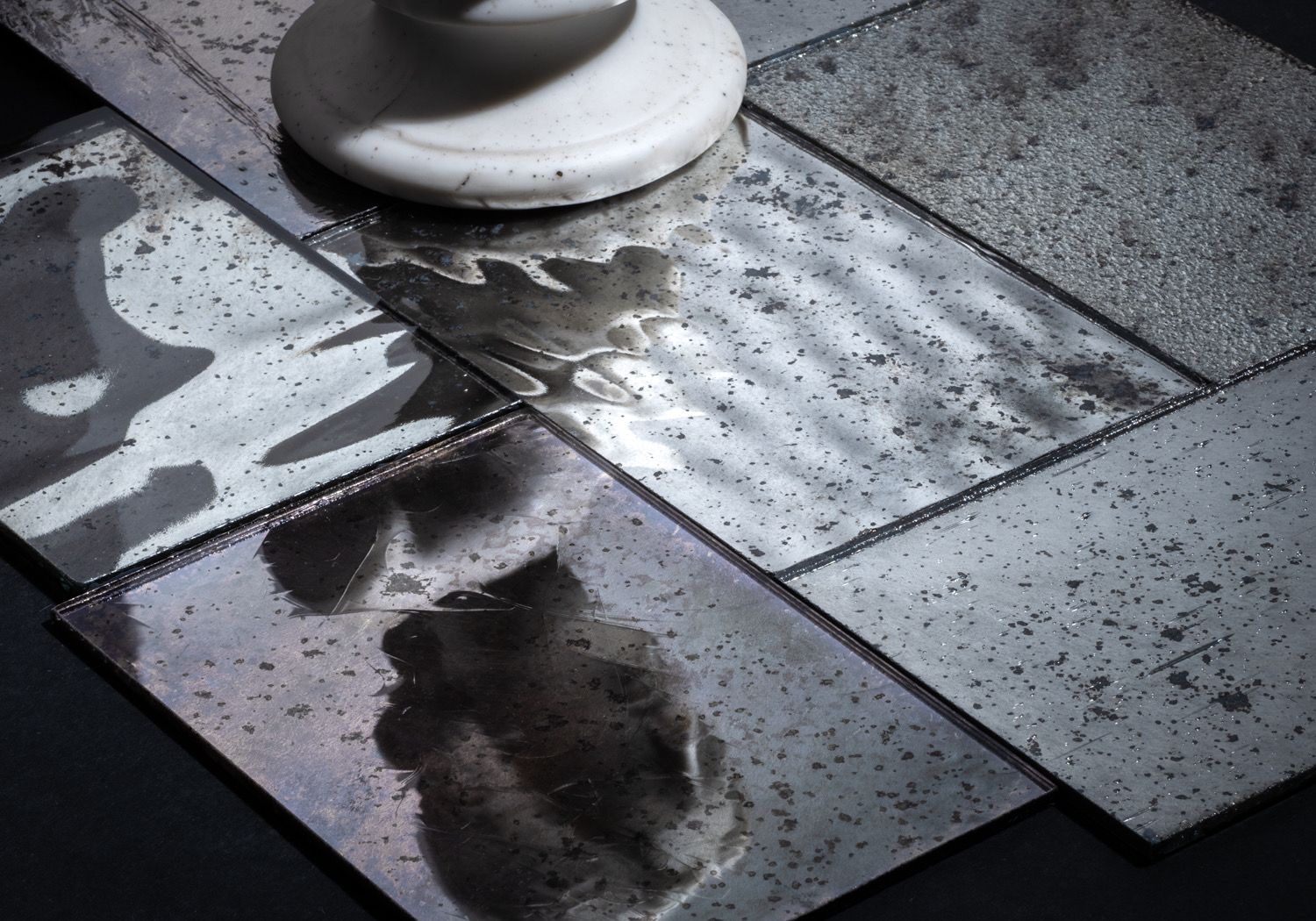 Dirty wet tiled floor with a mop head and a reflection in a puddle