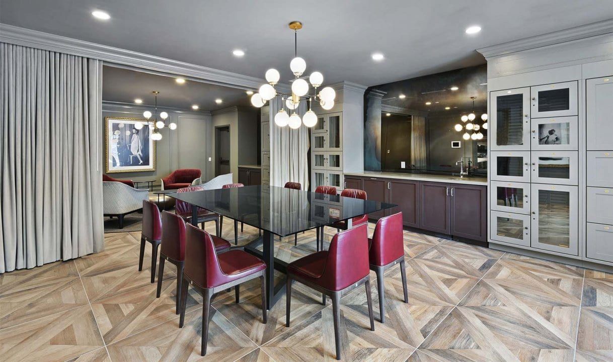 A large dining room with a table, chairs and a large antique mirror