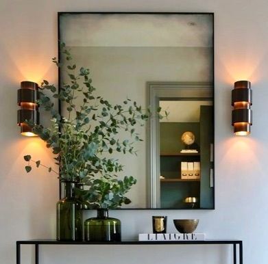 A large mirror is hanging on a wall above a table